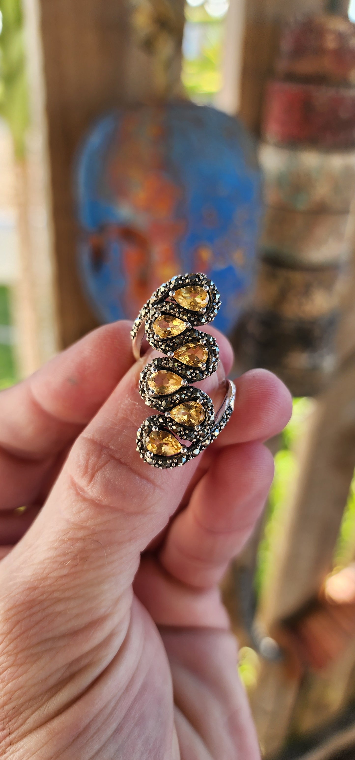 This sterling silver bypass style ring is an absolute showstopper, exuding a bold vintage aesthetic with its ornate craftsmanship and radiant gemstone arrangement.