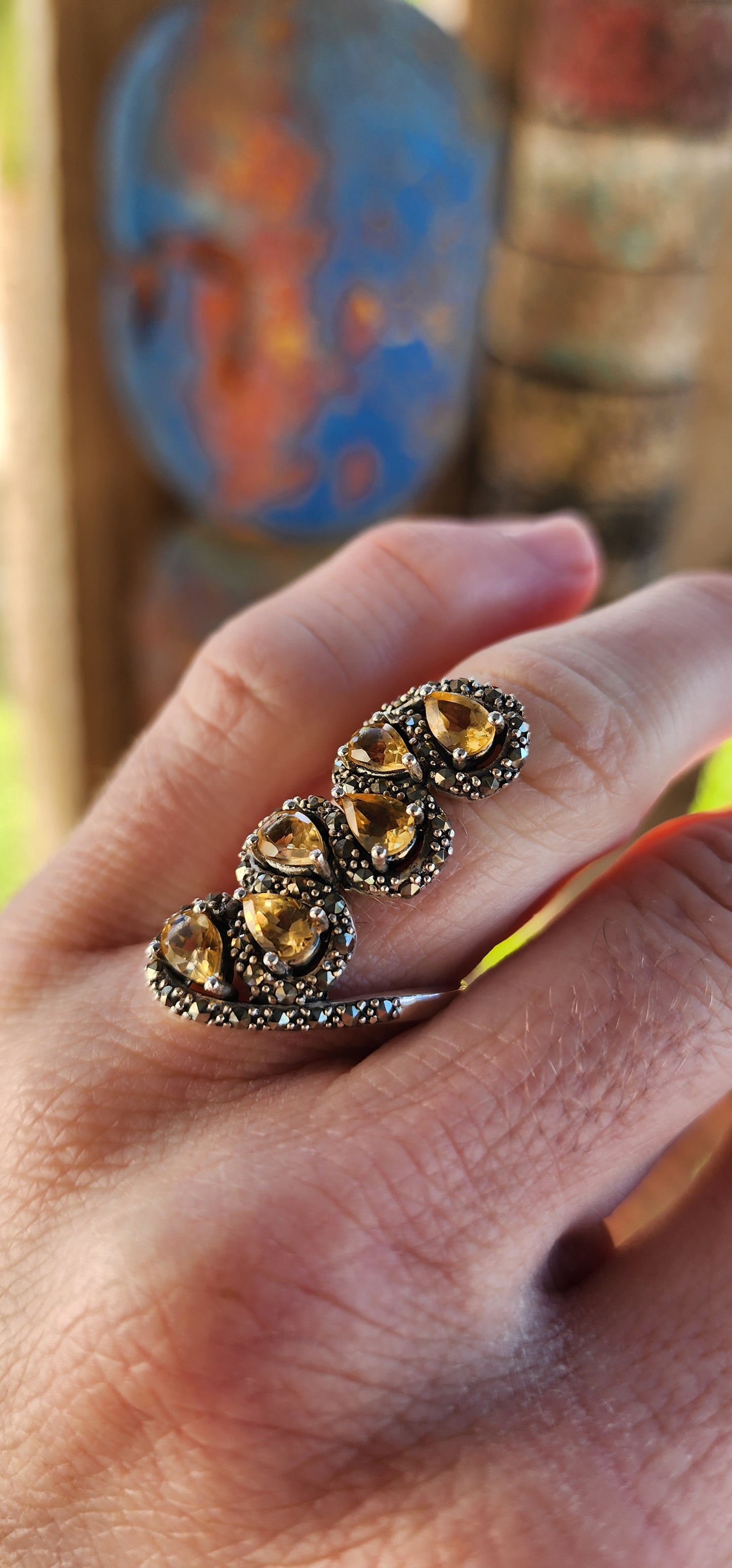 This sterling silver bypass style ring is an absolute showstopper, exuding a bold vintage aesthetic with its ornate craftsmanship and radiant gemstone arrangement.