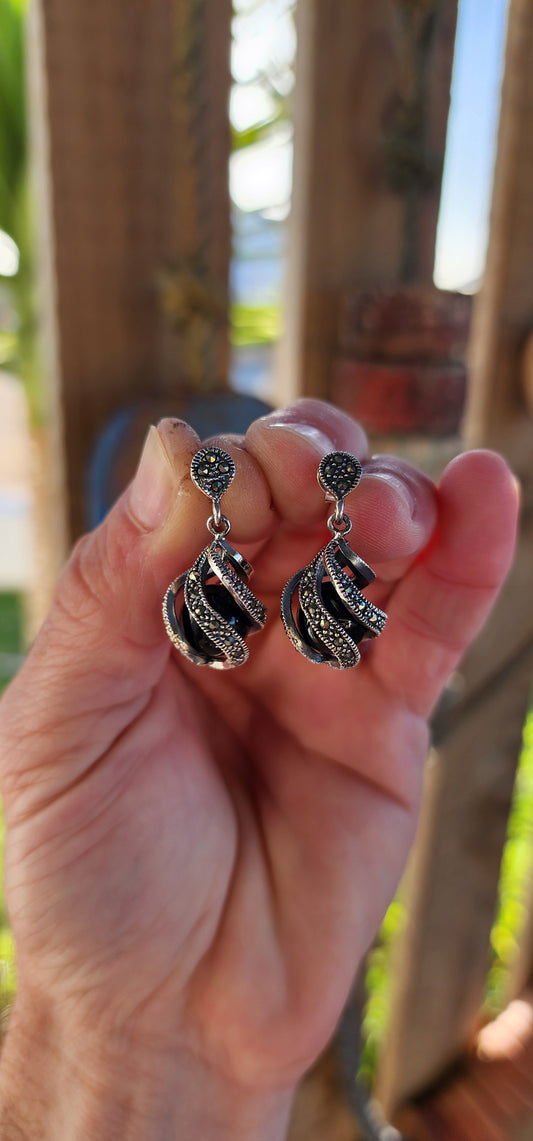 These exquisite sterling silver dangle earrings are a true embodiment of Art Deco sophistication, seamlessly blending architectural elegance with an air of mystique.