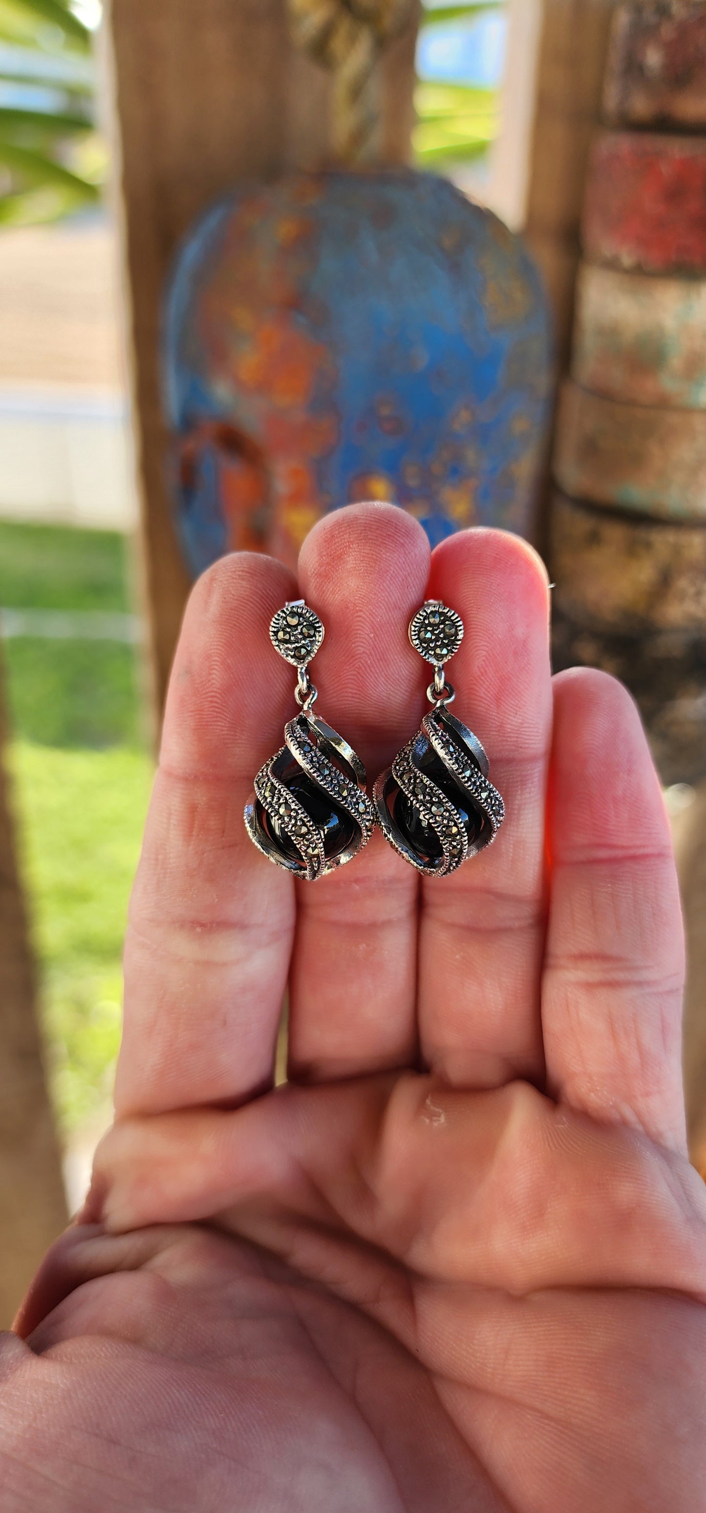 These exquisite sterling silver dangle earrings are a true embodiment of Art Deco sophistication, seamlessly blending architectural elegance with an air of mystique.