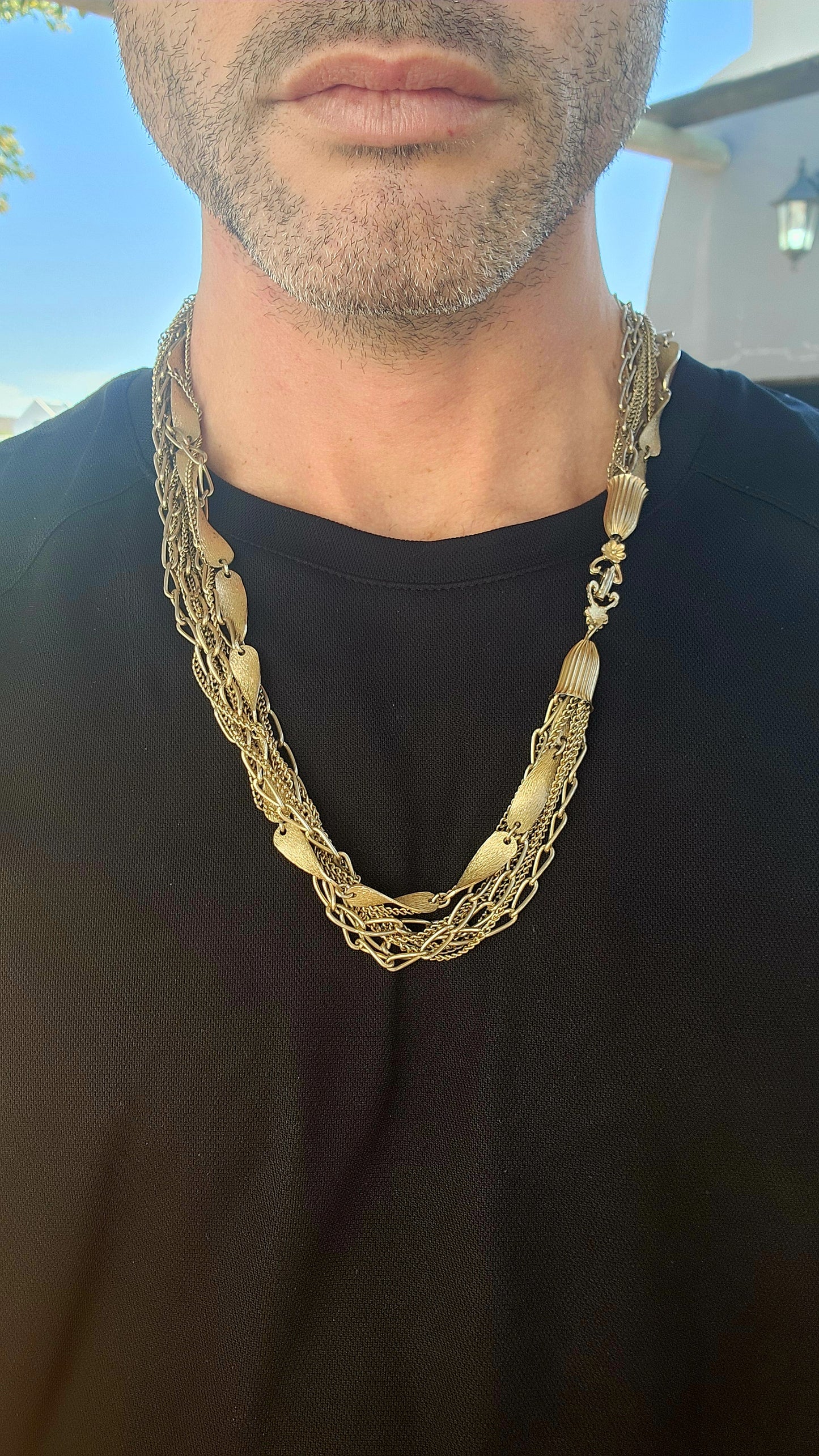 This vintage 1990s gold-plated multi-chain costume necklace is a stunning statement piece with an air of regal elegance and timeless charm.