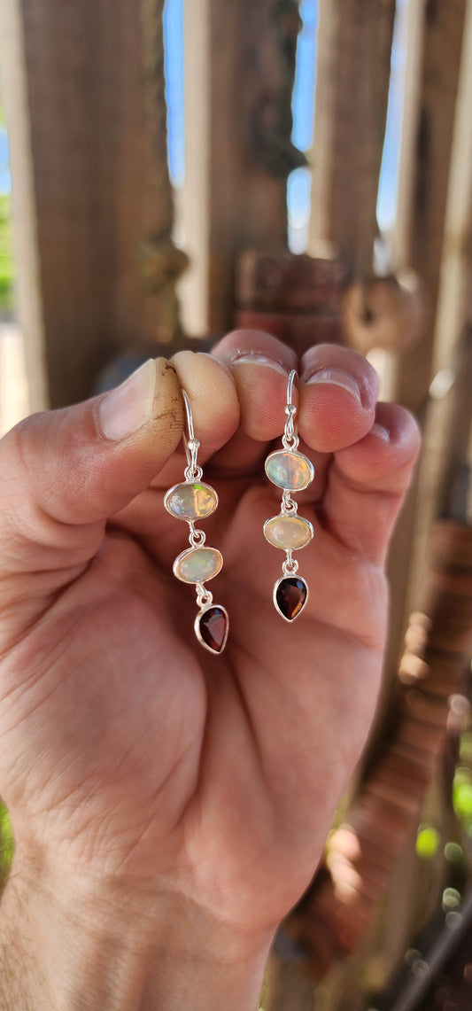 These exquisite sterling silver drop earrings are a mesmerizing fusion of fire and light, elegantly showcasing two birthstone options in a timeless, sophisticated design.