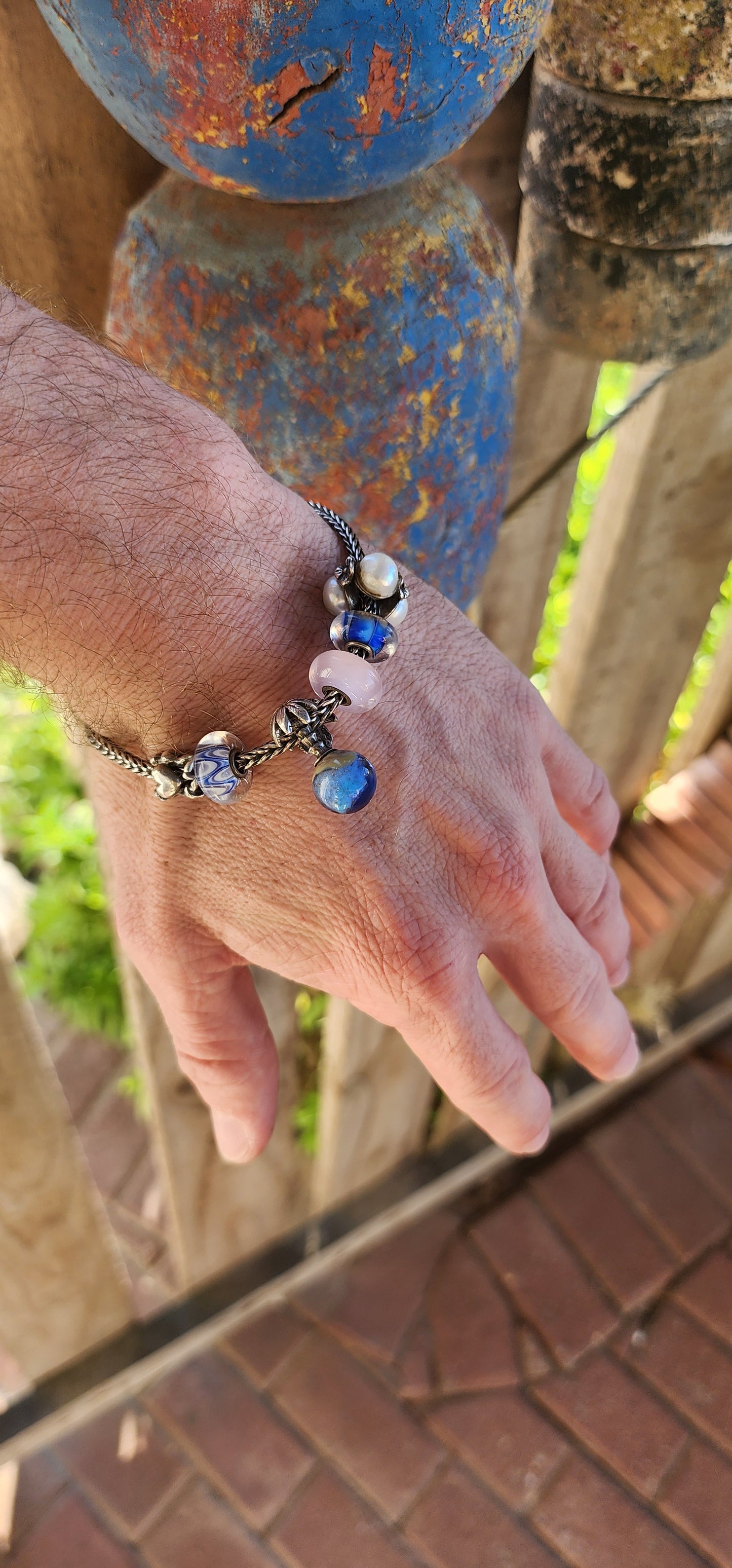 This T-r-o-l-l-b-e-a-d-s sterling silver charm bracelet is an exquisite piece that beautifully blends craftsmanship, storytelling, and luxury.