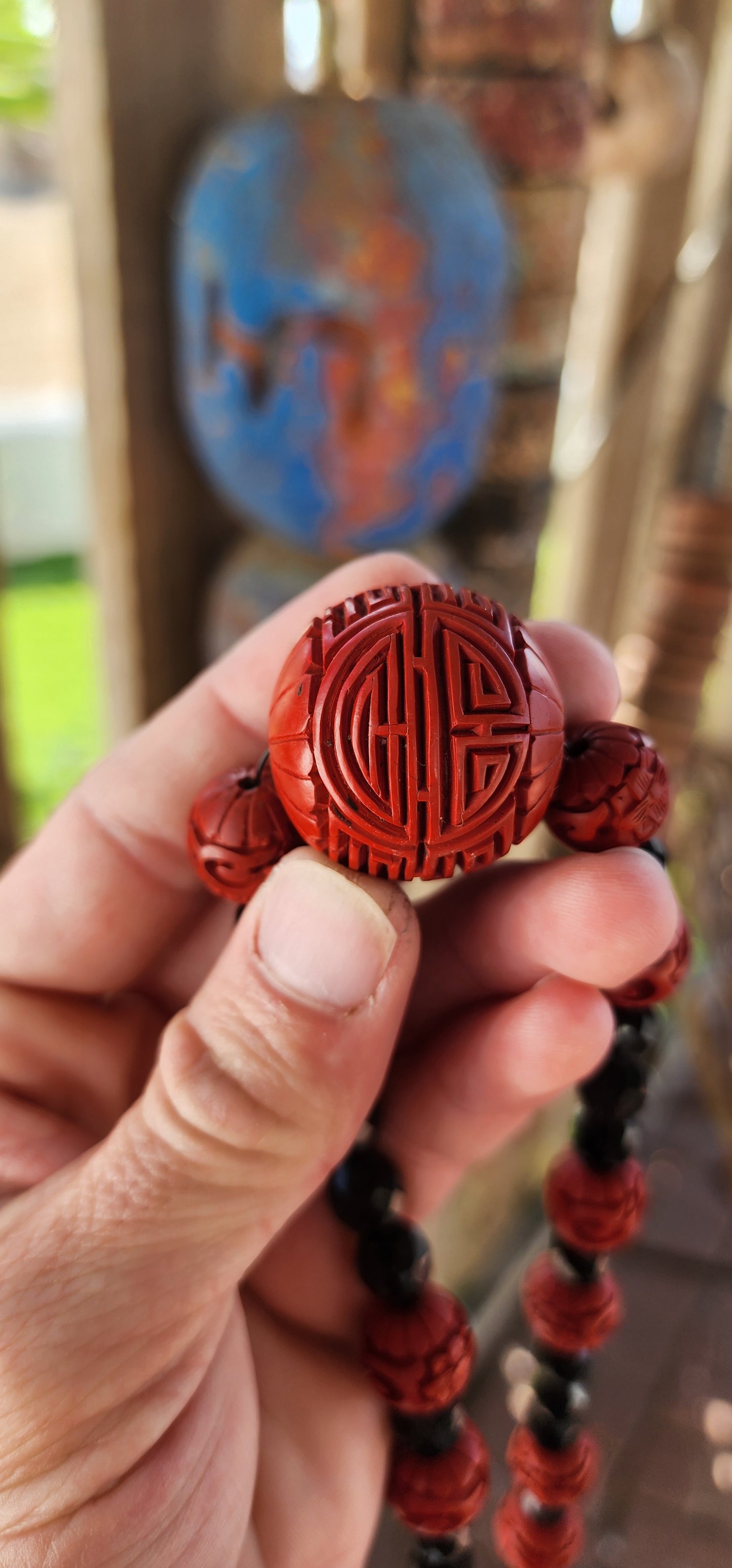 This vintage mid 20th century Chinese export necklace is a stunning example of traditional craftsmanship, featuring hand-carved cinnabar lacquer beads, faceted French jet glass beads, and a sterling silver magnetic clasp.