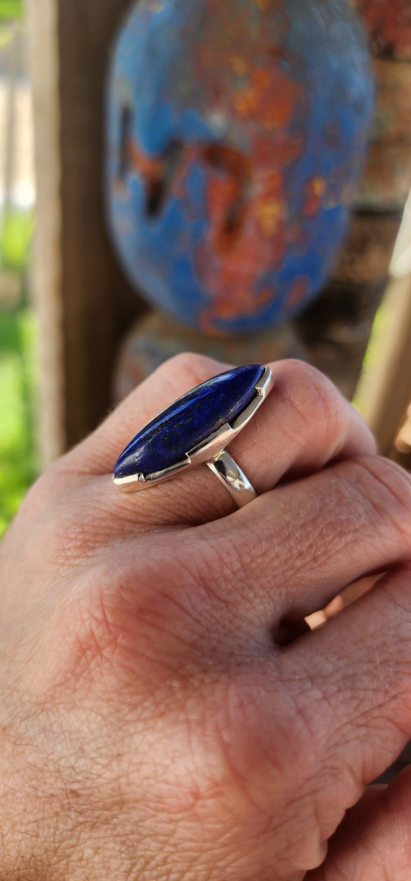 This stunning artisan-crafted statement ring is a true embodiment of bold elegance and refined craftsmanship. The piece is crafted from solid sterling silver, showcasing a magical, marquise cut Lapis Lazuli cabochon.