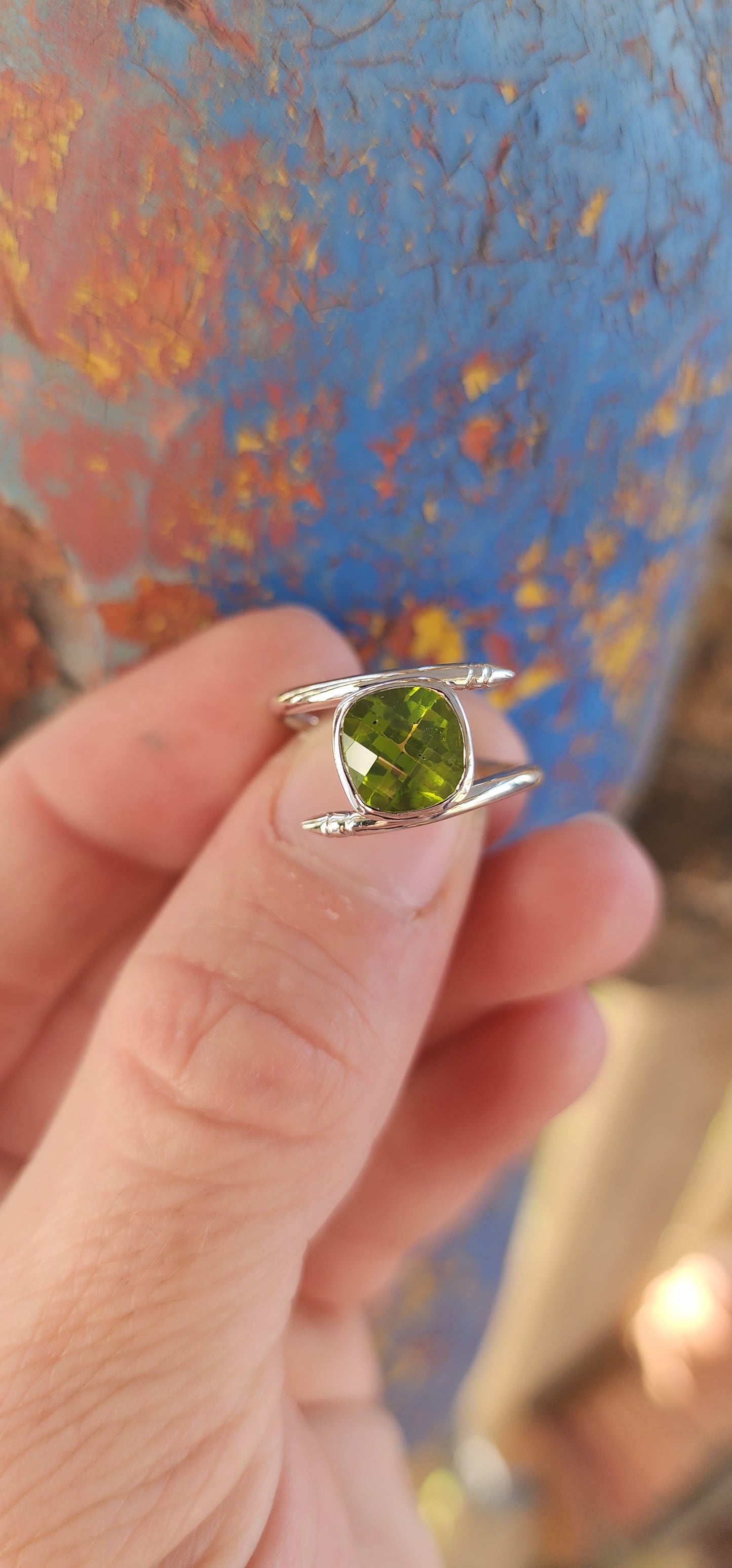 This unisex sterling silver bypass-style ring is a bold and striking fusion of contemporary industrial design and classic gemstone elegance.