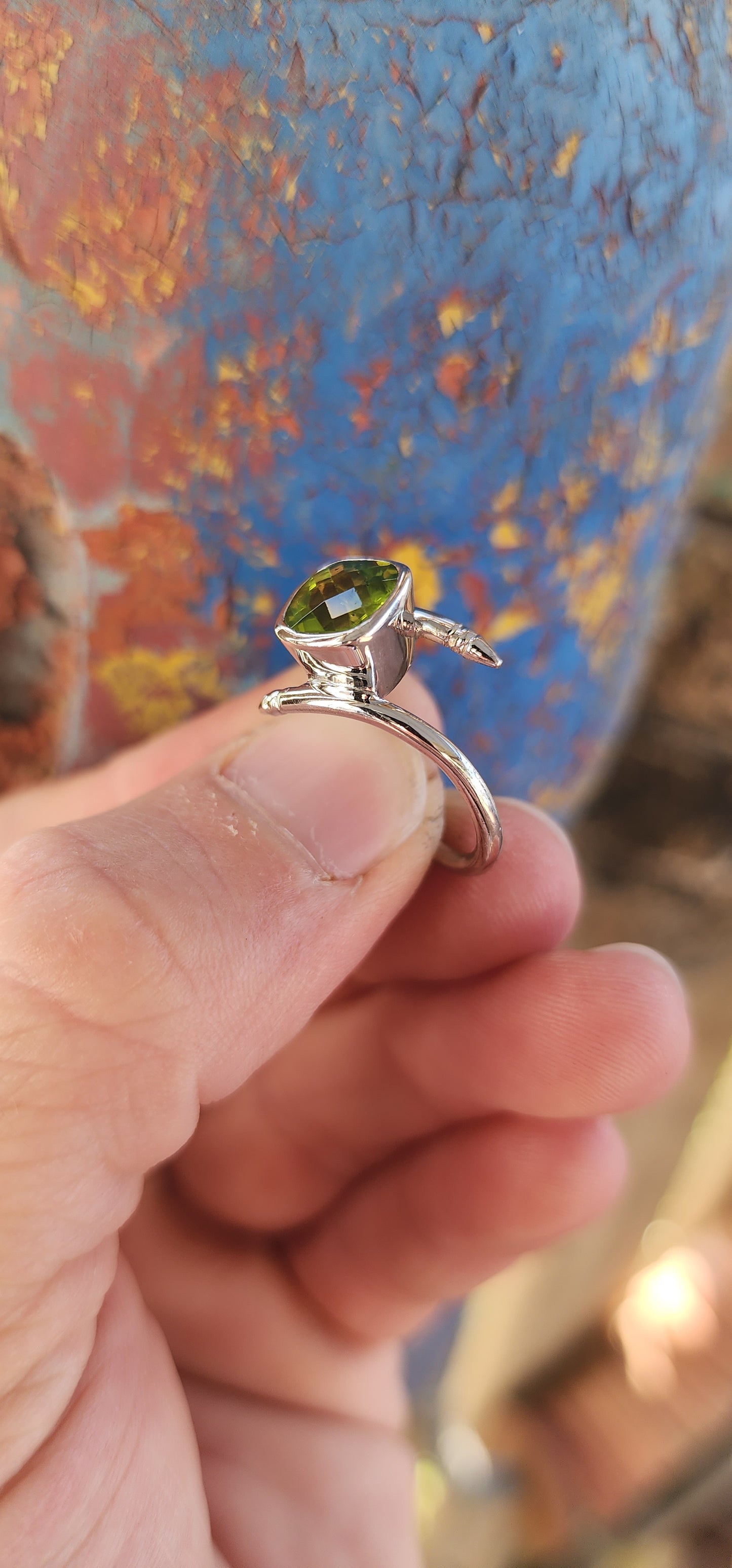 This unisex sterling silver bypass-style ring is a bold and striking fusion of contemporary industrial design and classic gemstone elegance.