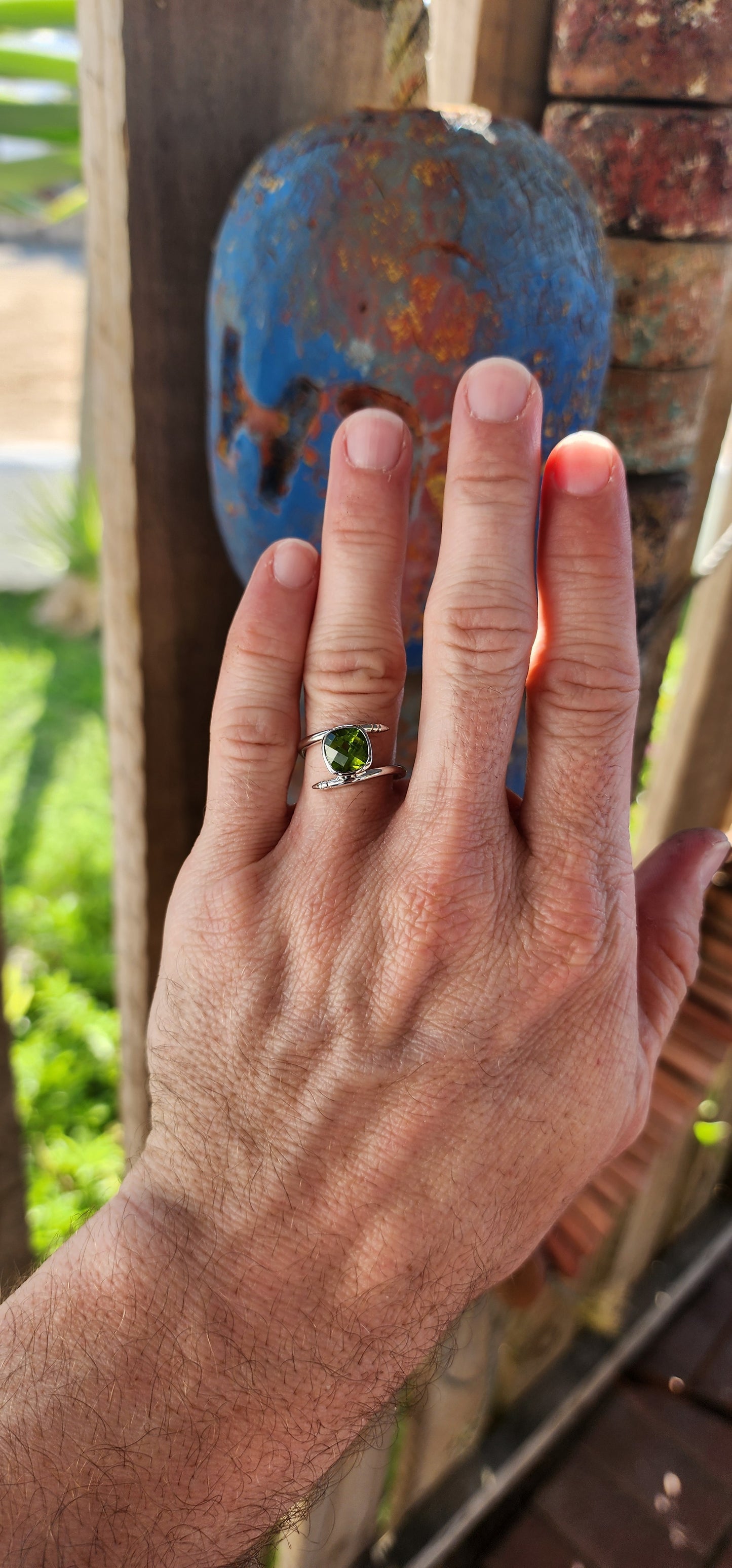 This unisex sterling silver bypass-style ring is a bold and striking fusion of contemporary industrial design and classic gemstone elegance.