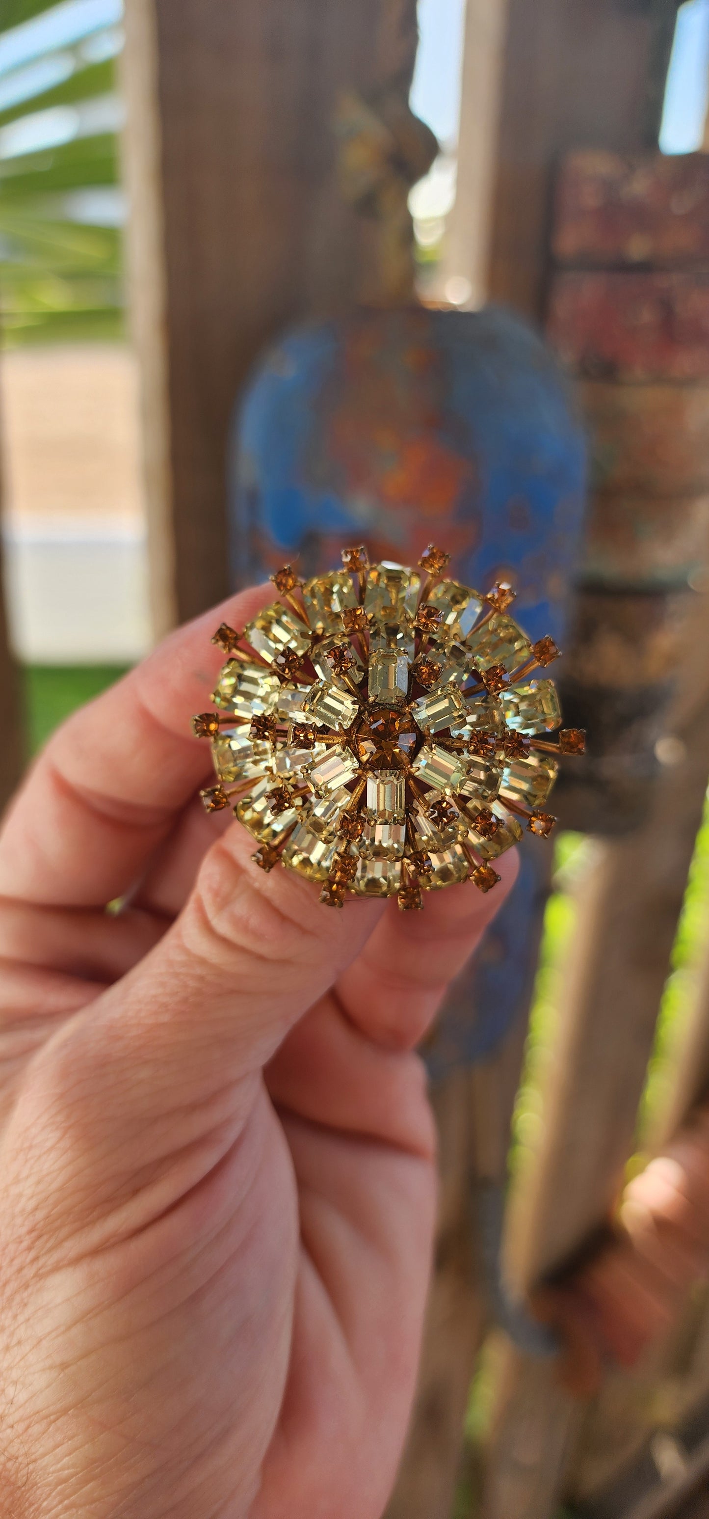 This 1950s vintage costume brooch is a dazzling statement piece that radiates mid-century glamour!
Crafted in a three-tiered domed sunburst shape, this brooch is an explosion of sparkle and sophistication.