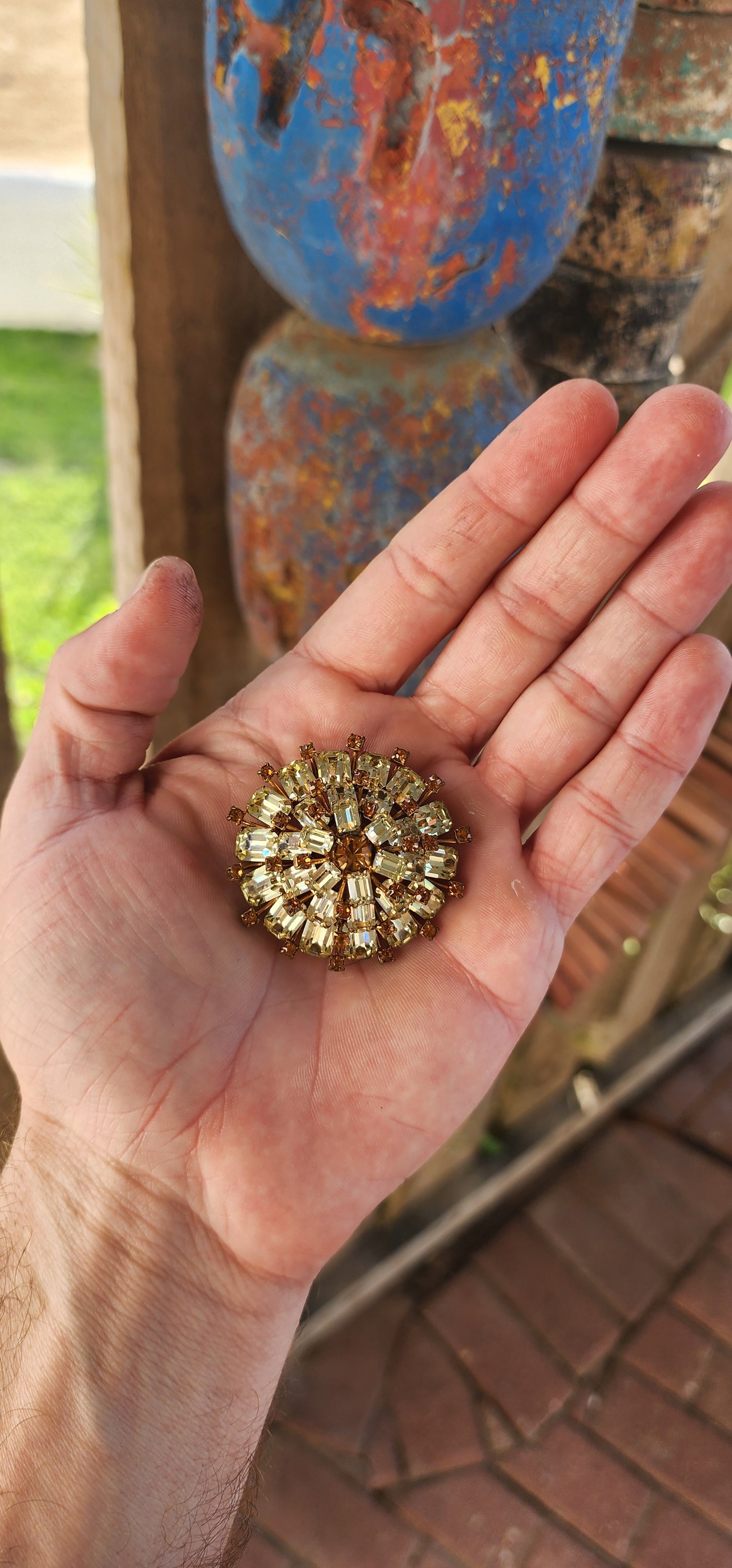 This 1950s vintage costume brooch is a dazzling statement piece that radiates mid-century glamour!
Crafted in a three-tiered domed sunburst shape, this brooch is an explosion of sparkle and sophistication.