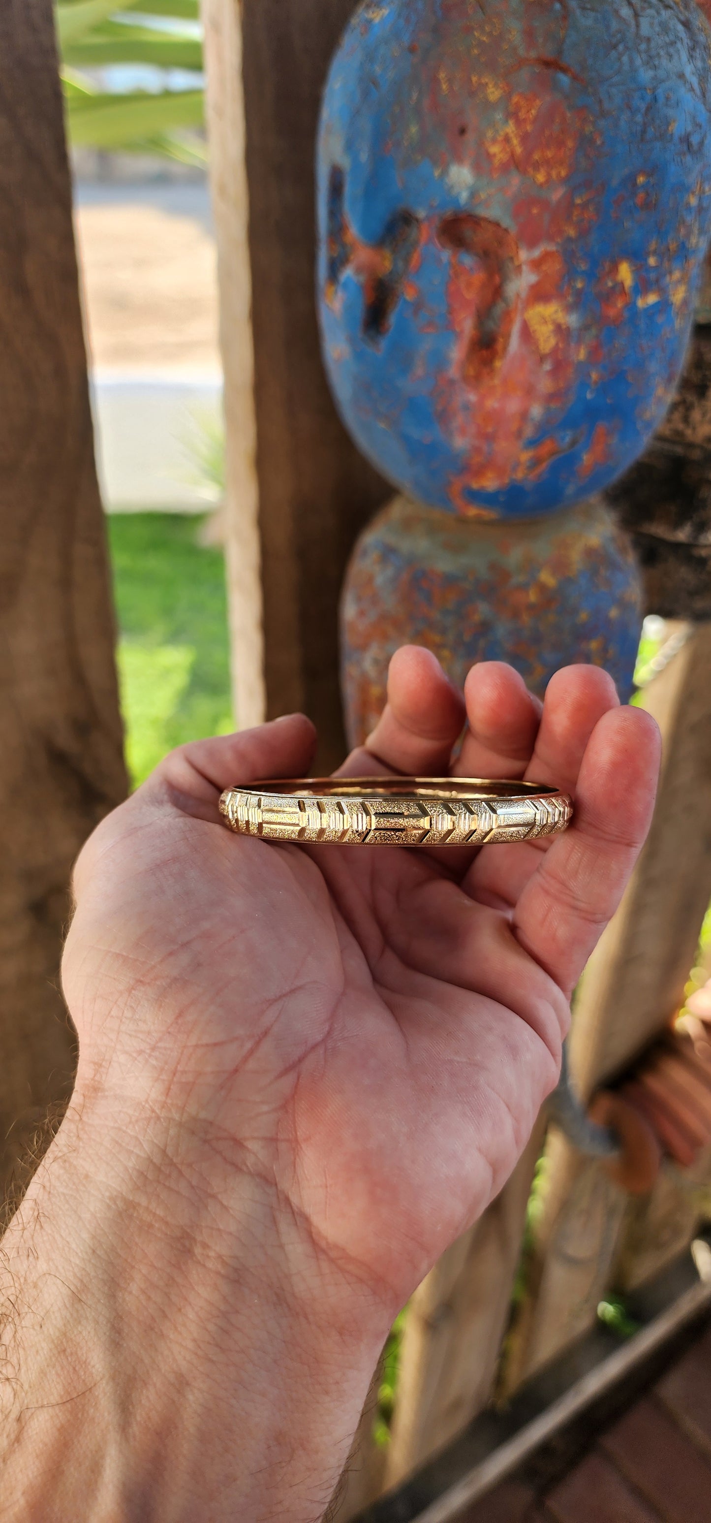 This vintage 9ct yellow gold bangle is a stunning example of classic elegance fused with exquisite craftsmanship. Designed in a domed C-shape, this bangle contours gracefully around the wrist, offering both a comfortable fit and a bold presence.