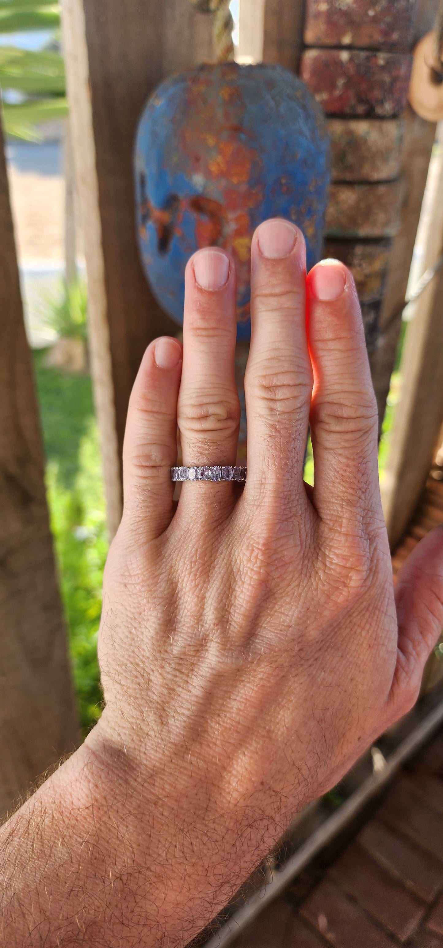 This exquisite full eternity ring is a testament to masterful craftsmanship and timeless elegance. Expertly forged in polished sterling silver, the ring showcases a seamless circle of 21 oval-cut Tanzanite gemstones.