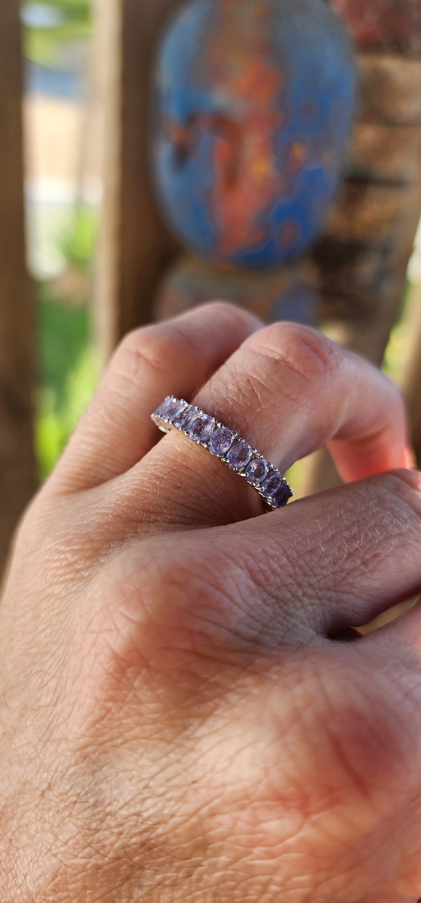 This exquisite full eternity ring is a testament to masterful craftsmanship and timeless elegance. Expertly forged in polished sterling silver, the ring showcases a seamless circle of 21 oval-cut Tanzanite gemstones.