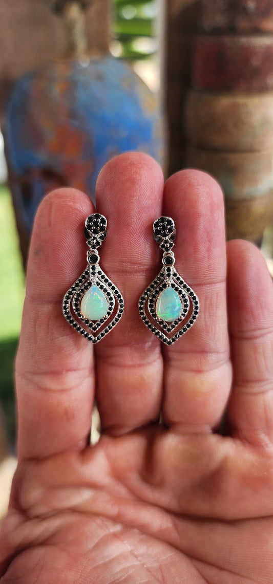 Opal Reverie – A Dance of Fire and Shadow!
Drape your ears in mystique with these absolutely showstopping sterling silver drop earrings, where celestial shimmer meets gothic glamour!