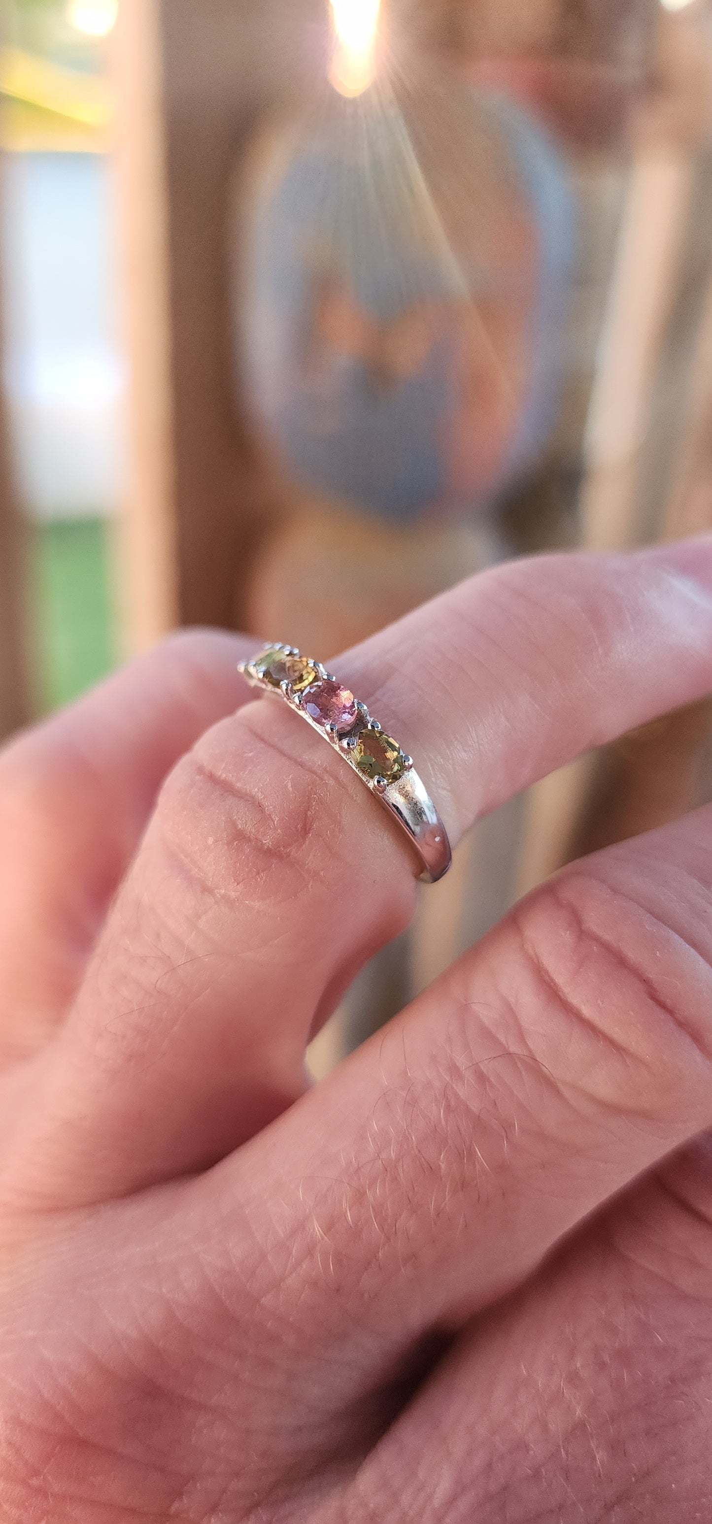 Let your fingers tell a story of color and wonder with this enchanting sterling silver half-eternity ring. Prong-set along the polished silver band are four oval-cut multi-colored tourmalines, each a glowing whisper of nature’s palette.