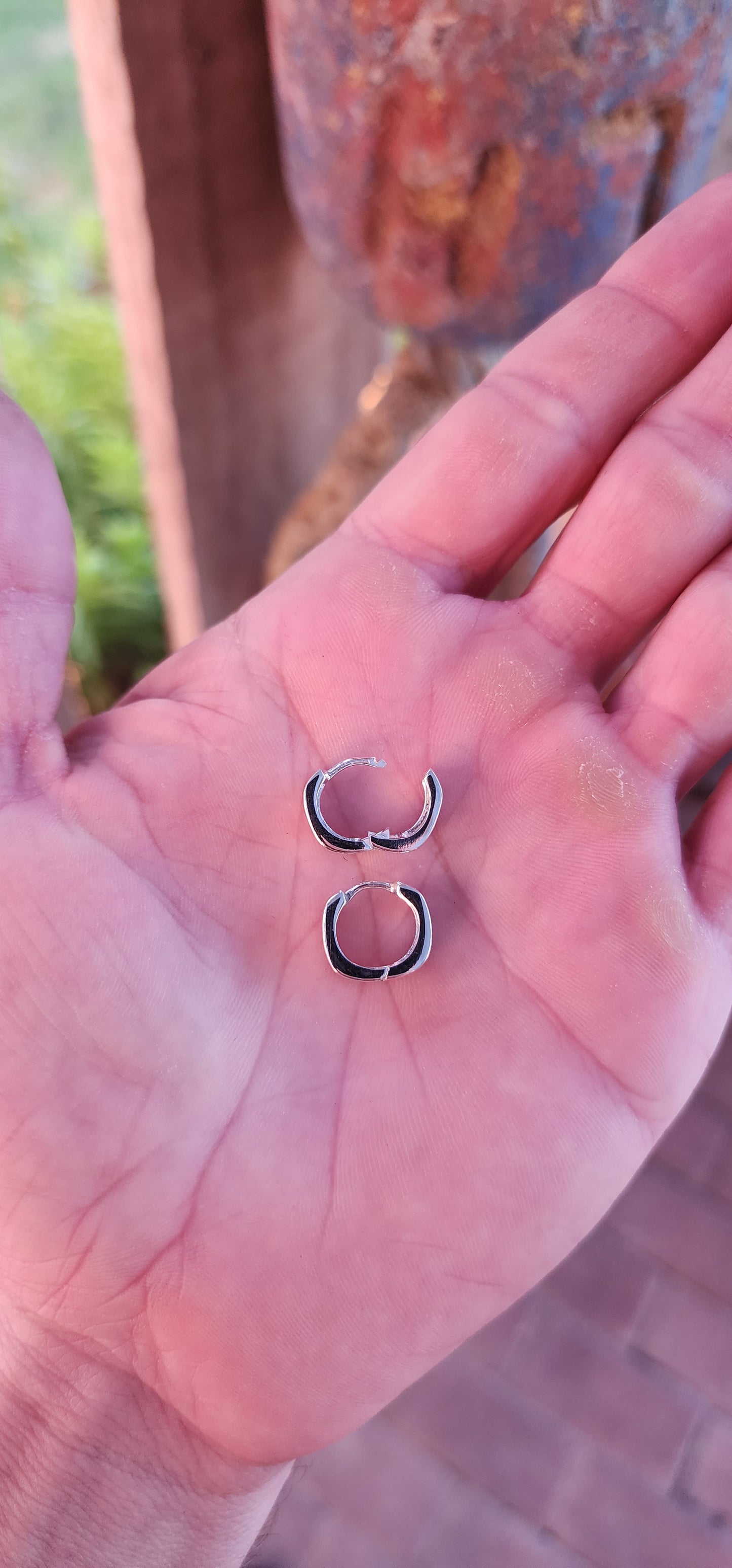These sterling silver huggie earrings are a masterclass in modern minimalism, sculpted in a bold rounded-rectangular shape that hugs the ear with contemporary charm.