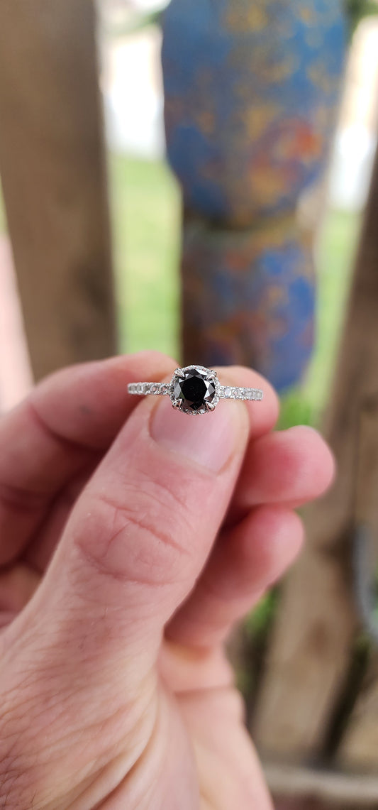 Prepare to swoon—this breathtaking sterling silver solitaire ring is pure romantic rebellion. At its heart sits a bold and dramatic round-cut black diamond, prong-set in gothic claw-like talons that grip it like a dragon guards its treasure.