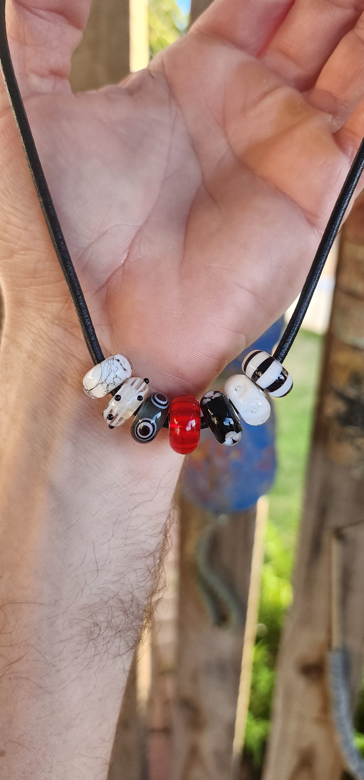 Channeling both modern cool and mystical charm, this unisex designer necklace by T-r-o-l-l-b-e-a-d-s is a wearable piece of art.