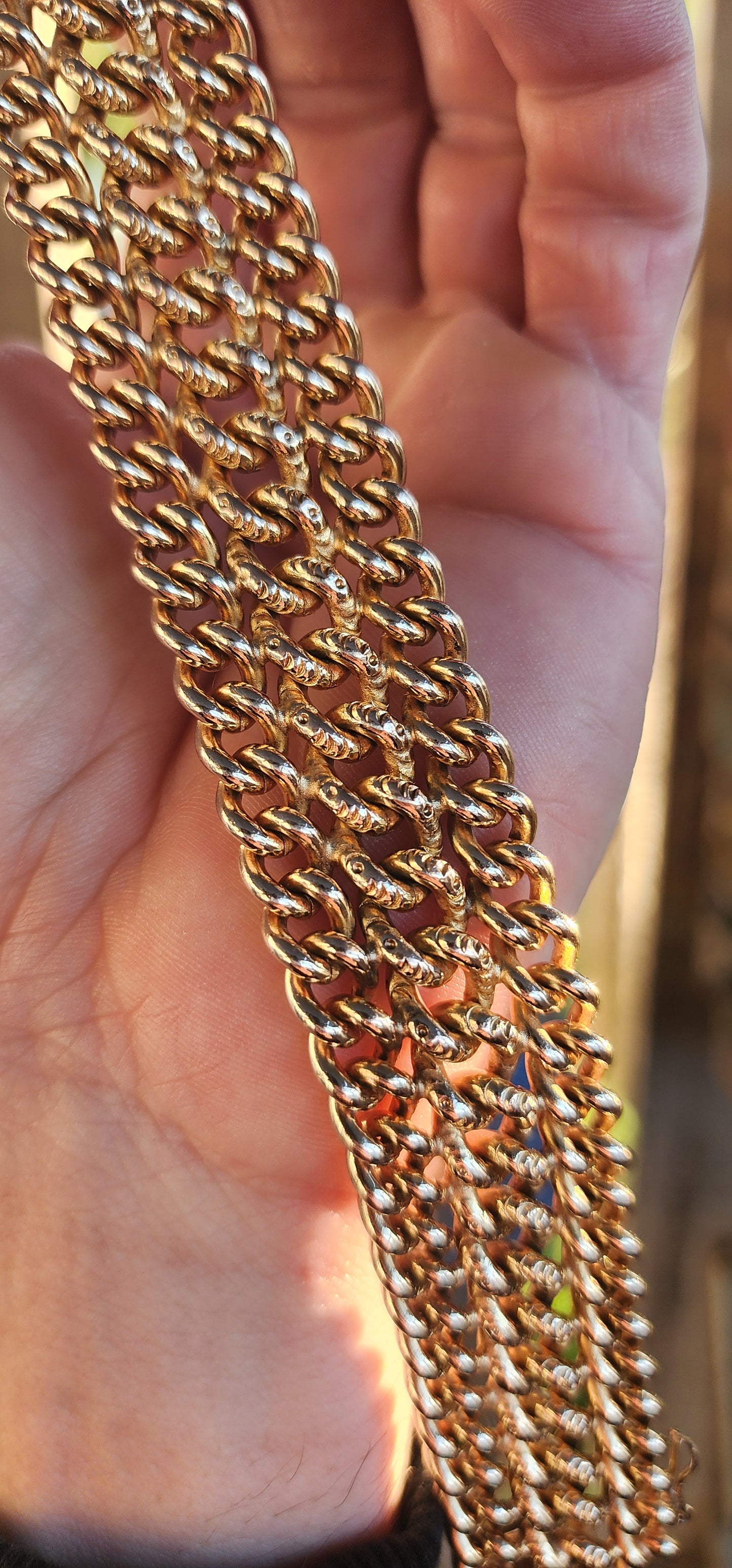 A rare survivor of mid-century mastery, this vintage rosy-yellow gold plated bracelet transforms simple curb links into a richly textured tapestry of bold elegance.
