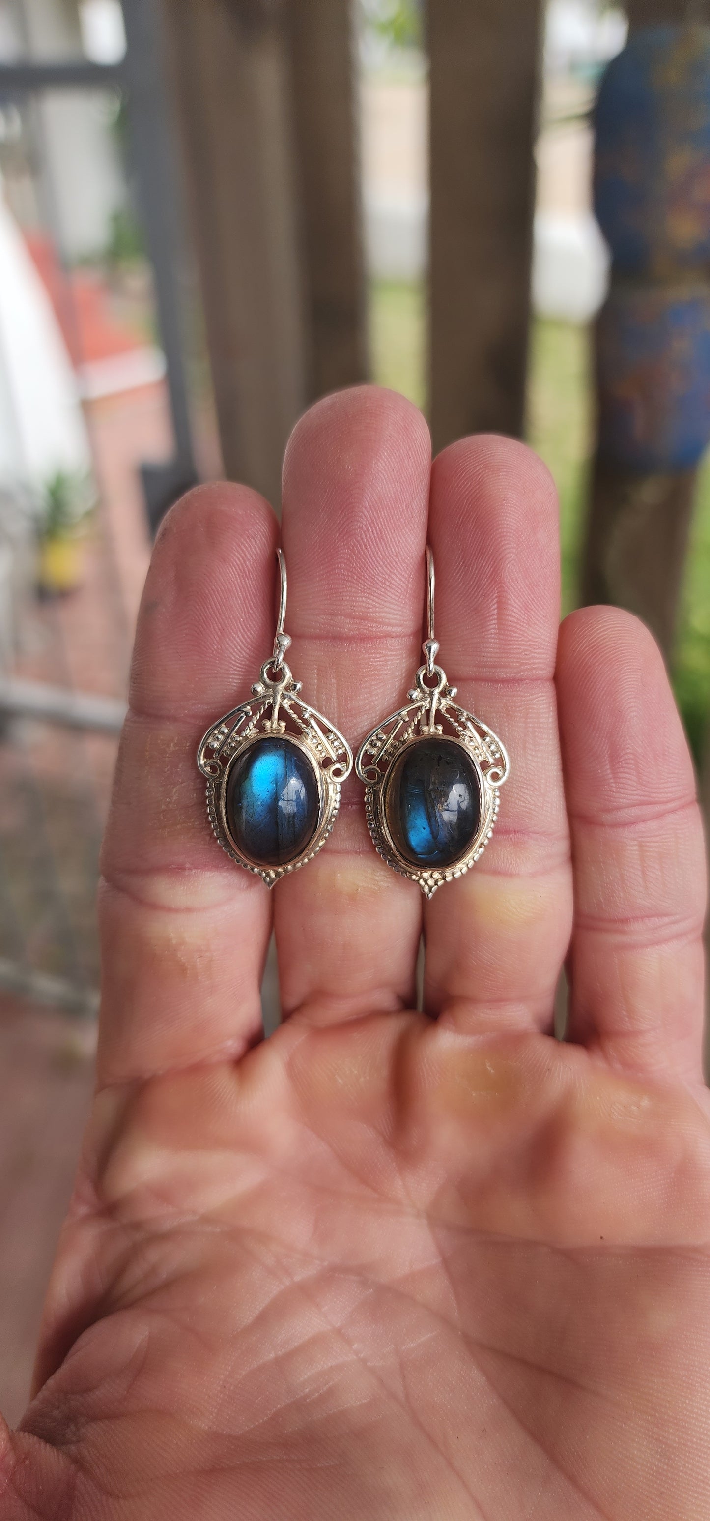 These enchanting sterling silver drop earrings are a romantic nod to the Art Nouveau era, featuring oval labradorite cabochons bezel-set atop intricate lace-like filigree backings.