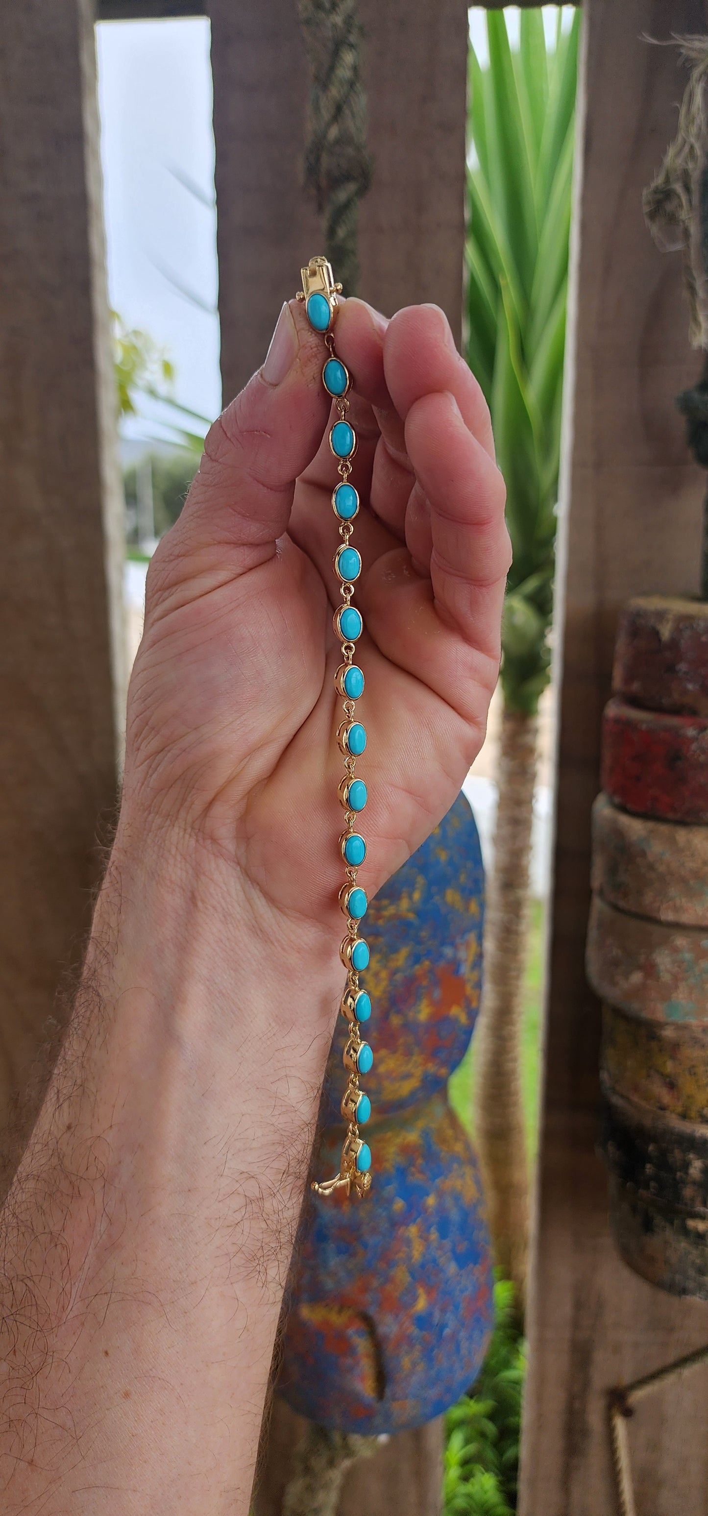 This beautiful tennis bracelet is crafted in sterling silver and finished with rich 18ct yellow gold plating, giving it a warm, luxurious glow. It features a row of 16 oval sleeping beauty turquoise cabochons.