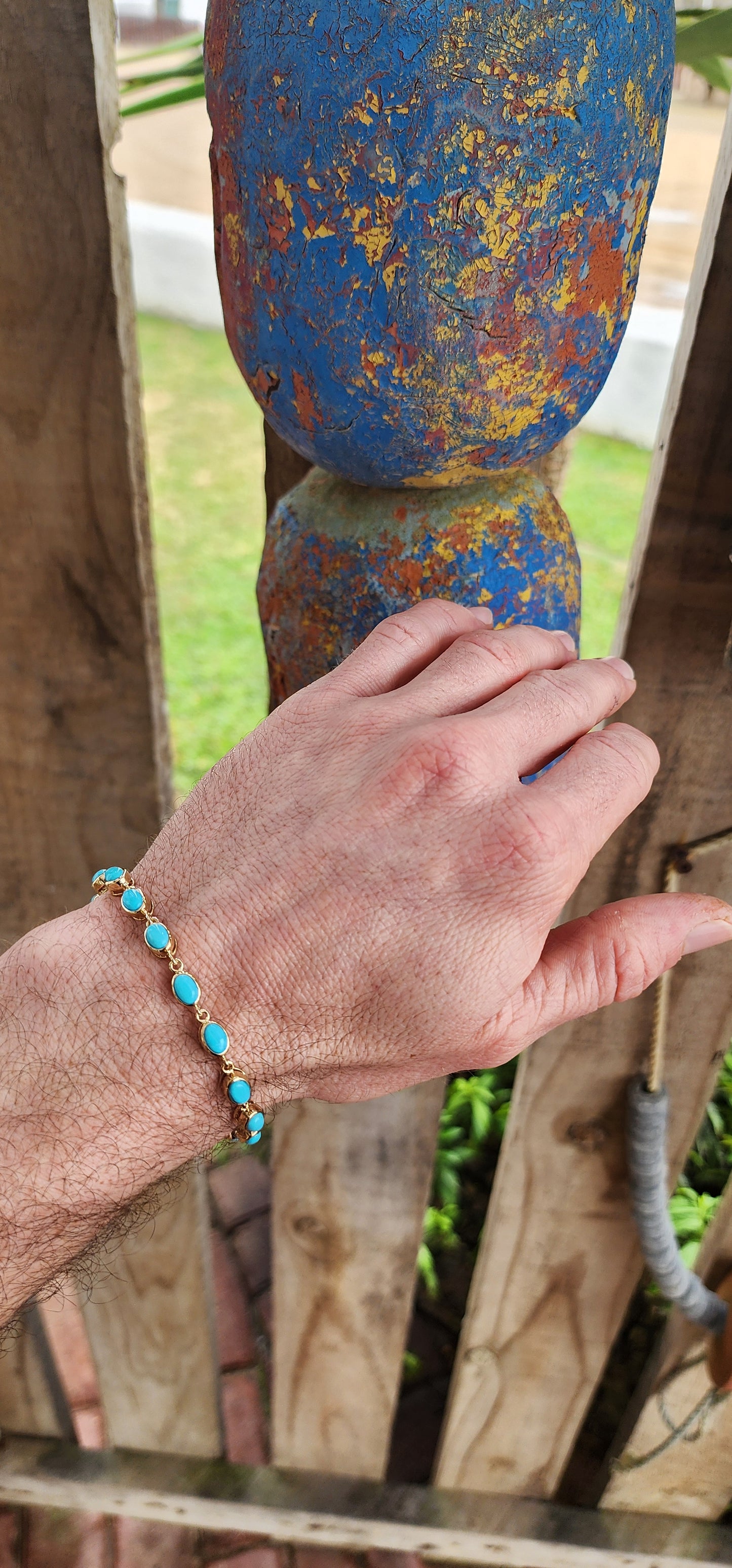 This beautiful tennis bracelet is crafted in sterling silver and finished with rich 18ct yellow gold plating, giving it a warm, luxurious glow. It features a row of 16 oval sleeping beauty turquoise cabochons.