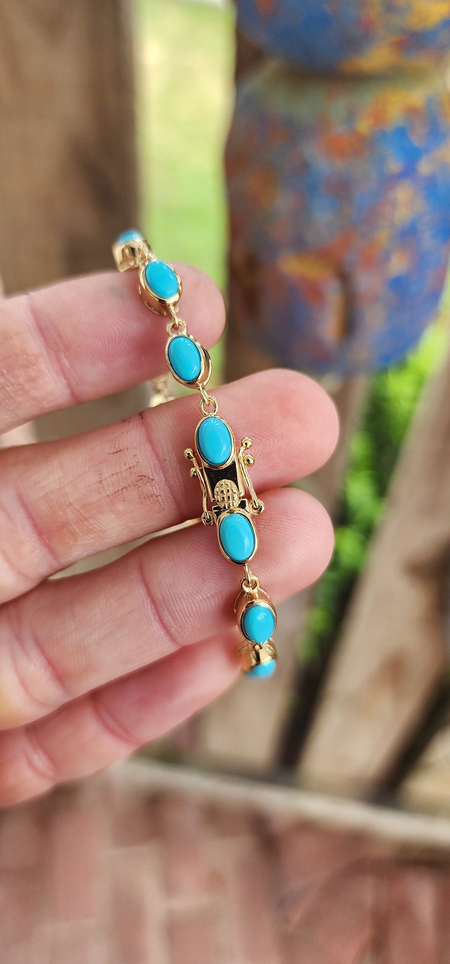 This beautiful tennis bracelet is crafted in sterling silver and finished with rich 18ct yellow gold plating, giving it a warm, luxurious glow. It features a row of 16 oval sleeping beauty turquoise cabochons.