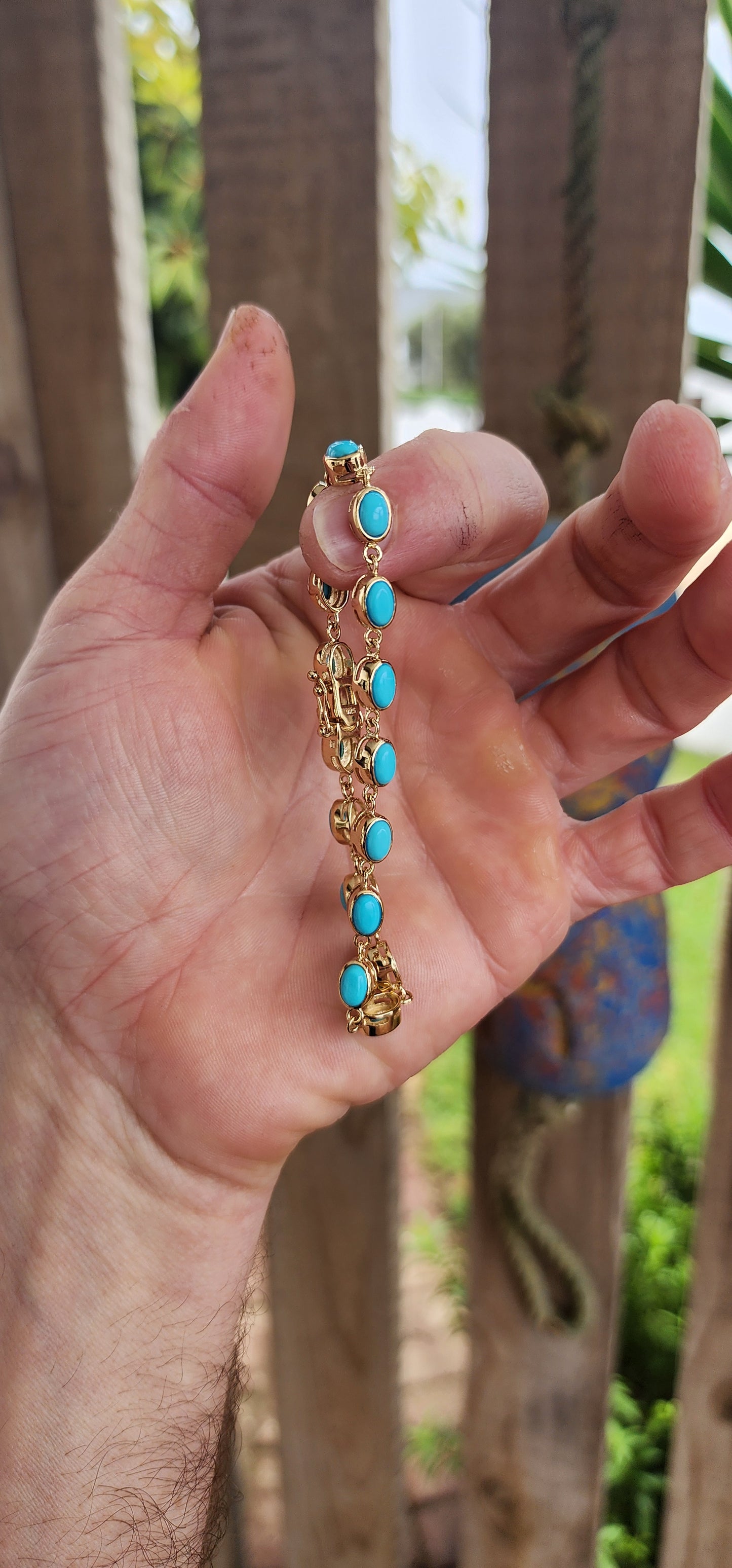 This beautiful tennis bracelet is crafted in sterling silver and finished with rich 18ct yellow gold plating, giving it a warm, luxurious glow. It features a row of 16 oval sleeping beauty turquoise cabochons.
