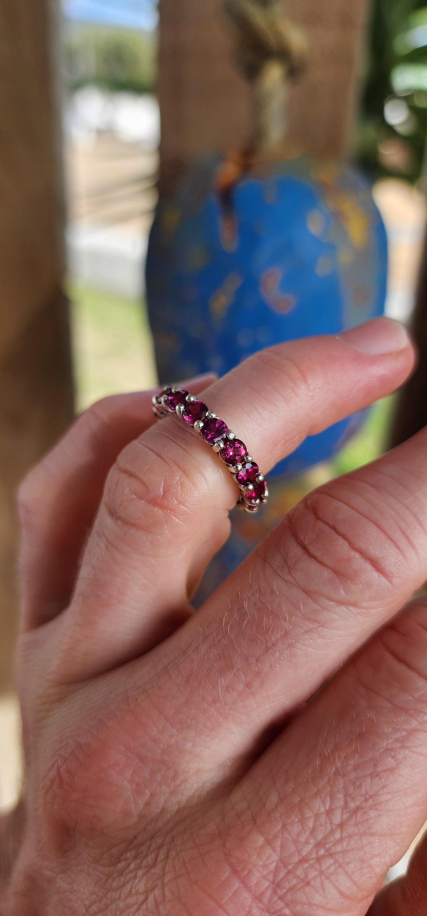 This sterling silver full eternity ring is set with 17 round-cut rhodolite garnets, each one meticulously claw-set to form an unbroken circle of luminous berry brilliance.