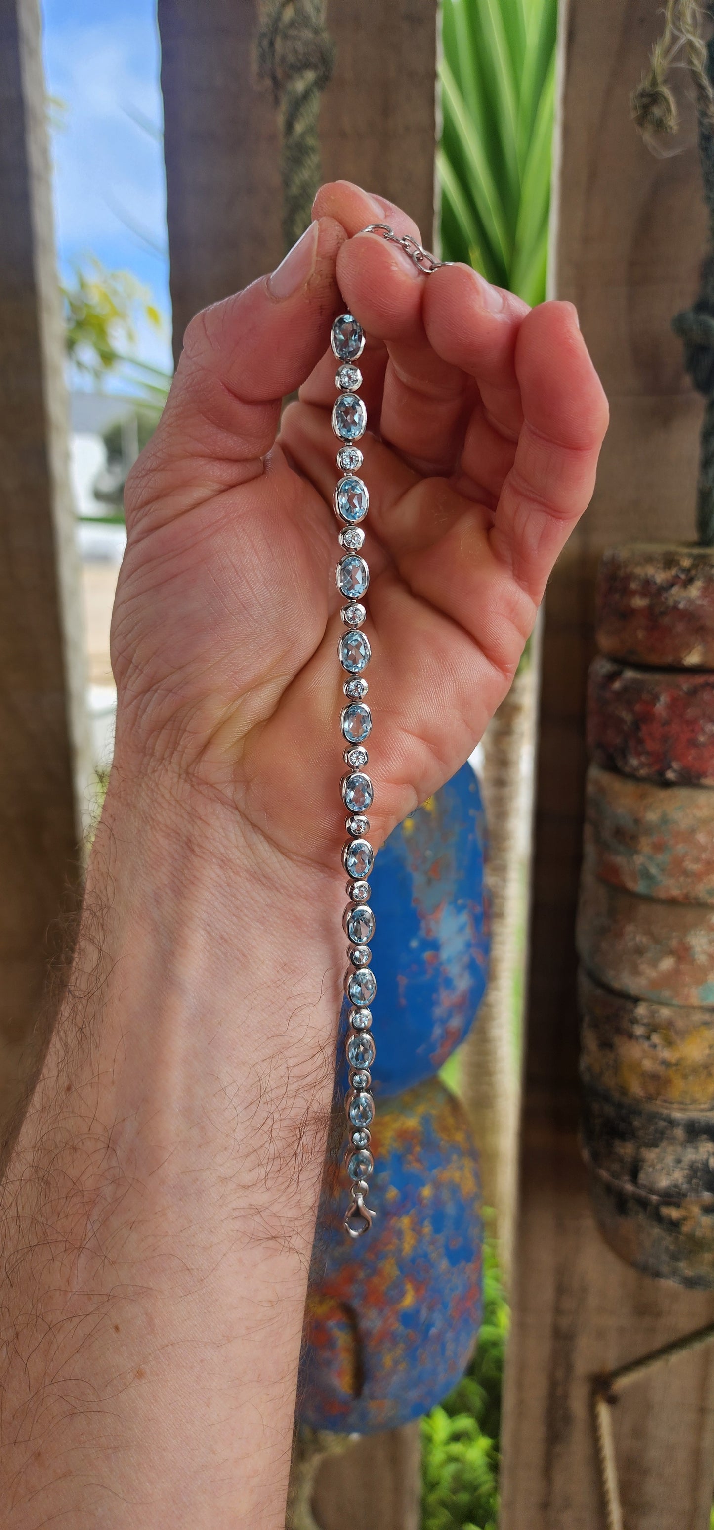 This dazzling bracelet is crafted in polished sterling silver, showcasing a graceful row of 24x sky blue topaz gemstones, each securely nestled in sleek tube bezel settings.
