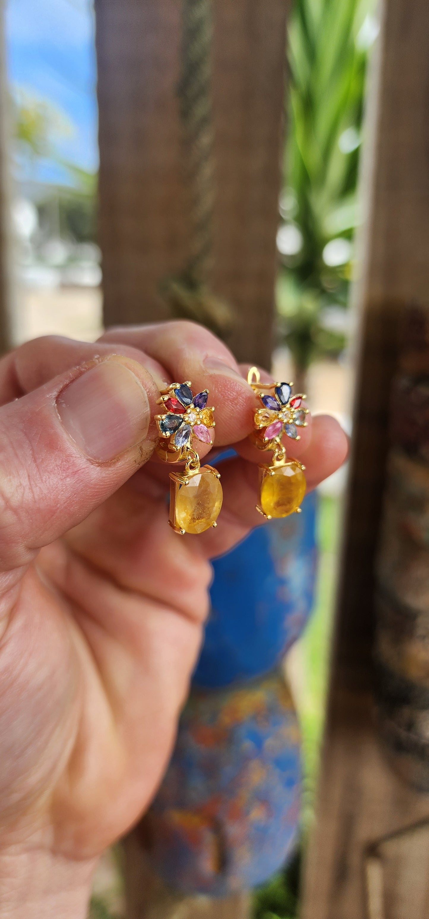 Fairytale Blossoms in Golden Light.
Crafted in sterling silver and plated in luxurious 18ct yellow gold, each earring begins with a radiant floral bloom, lovingly composed of colorful sapphires in playful pear and marquise cuts.