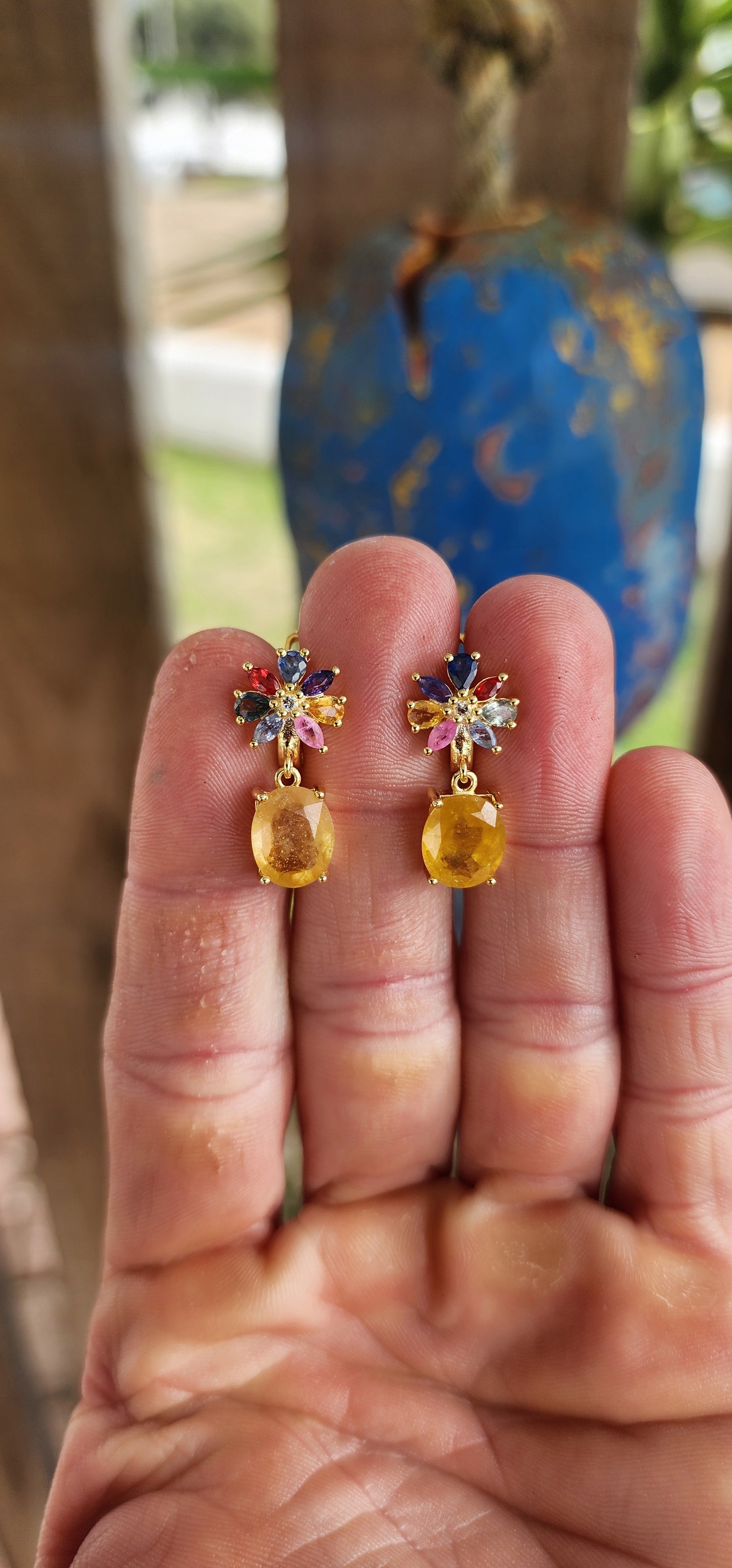 Fairytale Blossoms in Golden Light.
Crafted in sterling silver and plated in luxurious 18ct yellow gold, each earring begins with a radiant floral bloom, lovingly composed of colorful sapphires in playful pear and marquise cuts.