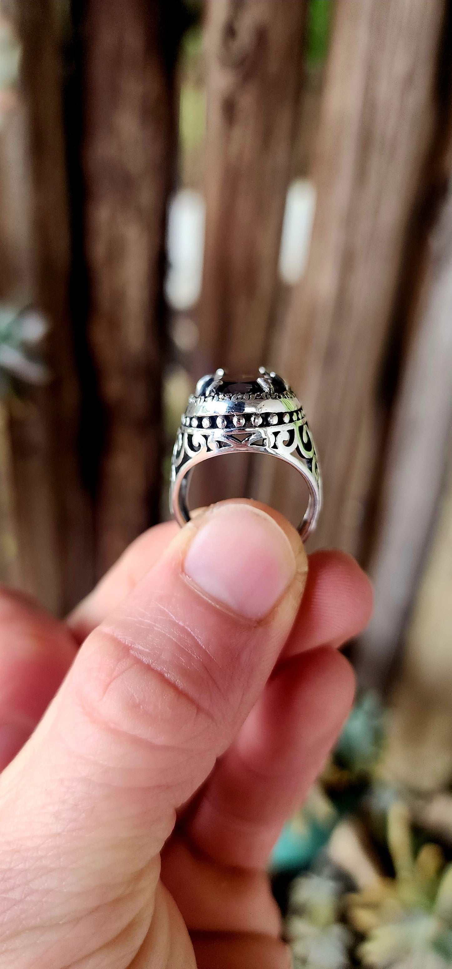 This bold and beautifully crafted sterling silver cocktail ring channels the grandeur of antique jewelry design. At its heart lies a large and rare oval-cut champagne/brown topaz.