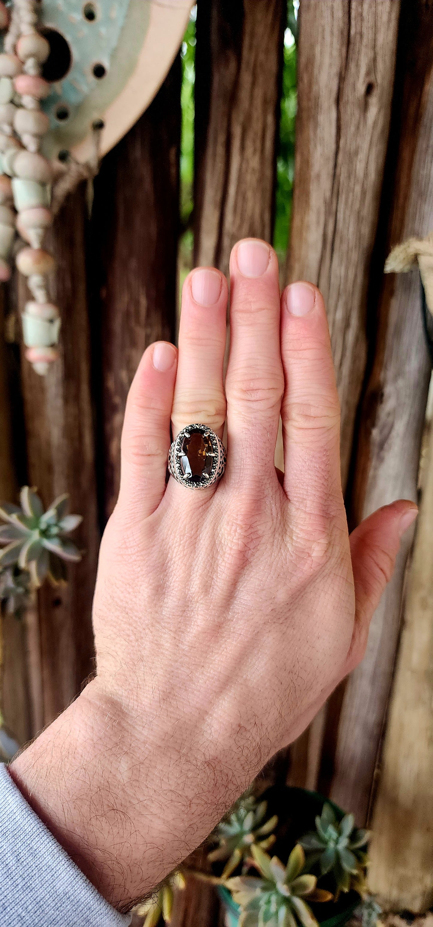 This bold and beautifully crafted sterling silver cocktail ring channels the grandeur of antique jewelry design. At its heart lies a large and rare oval-cut champagne/brown topaz.