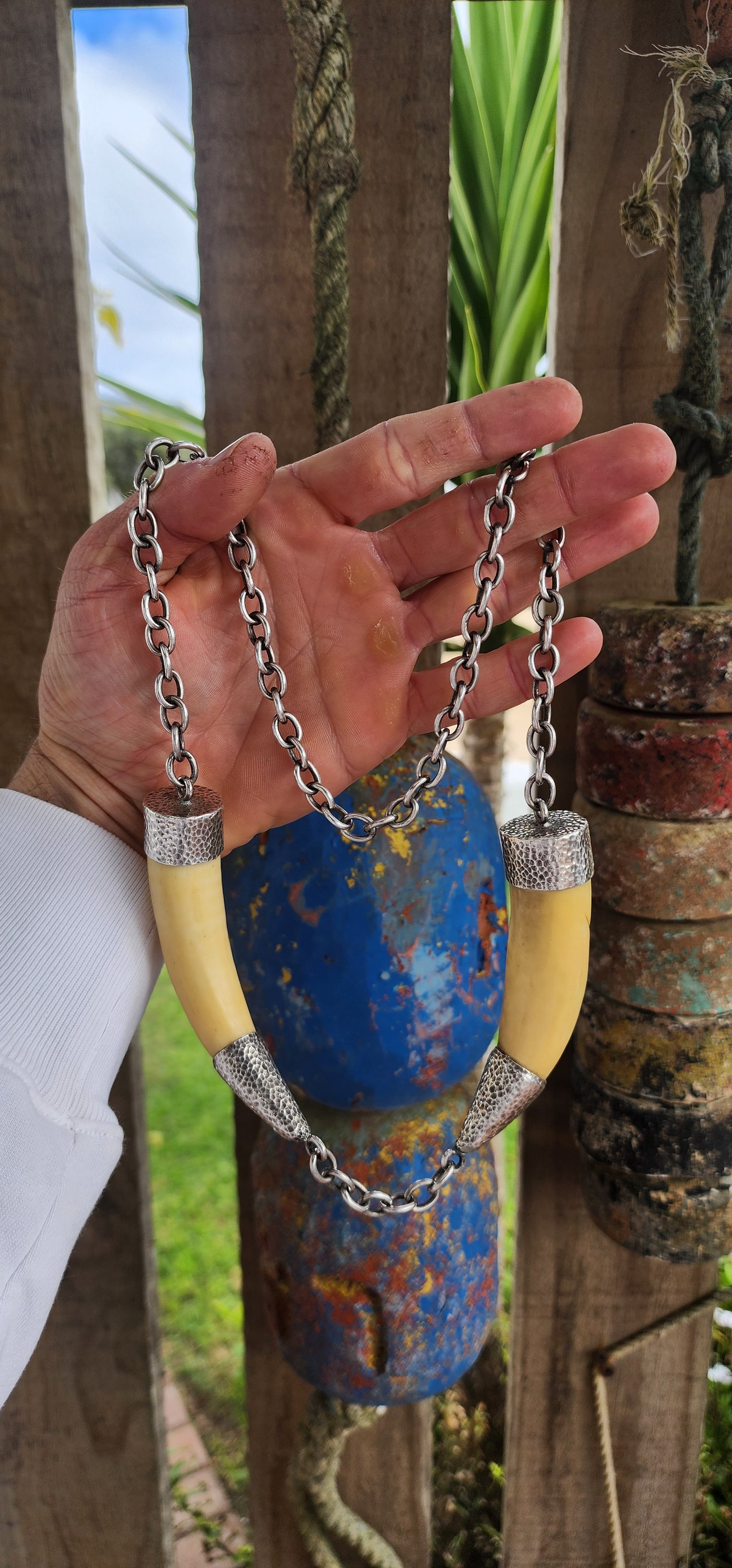 This extraordinary antique STATEMENT necklace radiates bold Viking spirit and primal strength. Its centerpiece features two impressive and large wild boar tusks, naturally aged to a warm creamy hue that speaks of history and heritage.
