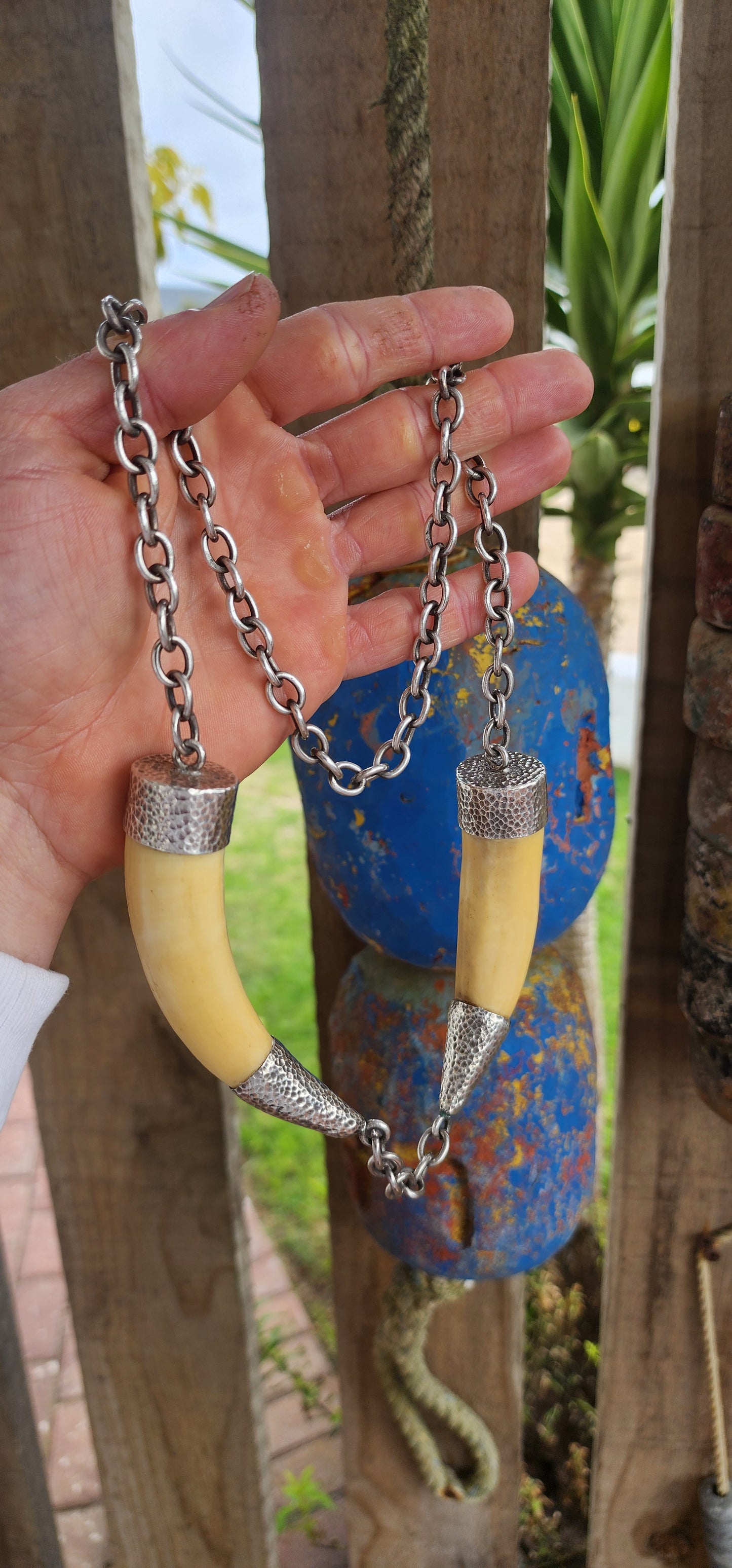 This extraordinary antique STATEMENT necklace radiates bold Viking spirit and primal strength. Its centerpiece features two impressive and large wild boar tusks, naturally aged to a warm creamy hue that speaks of history and heritage.