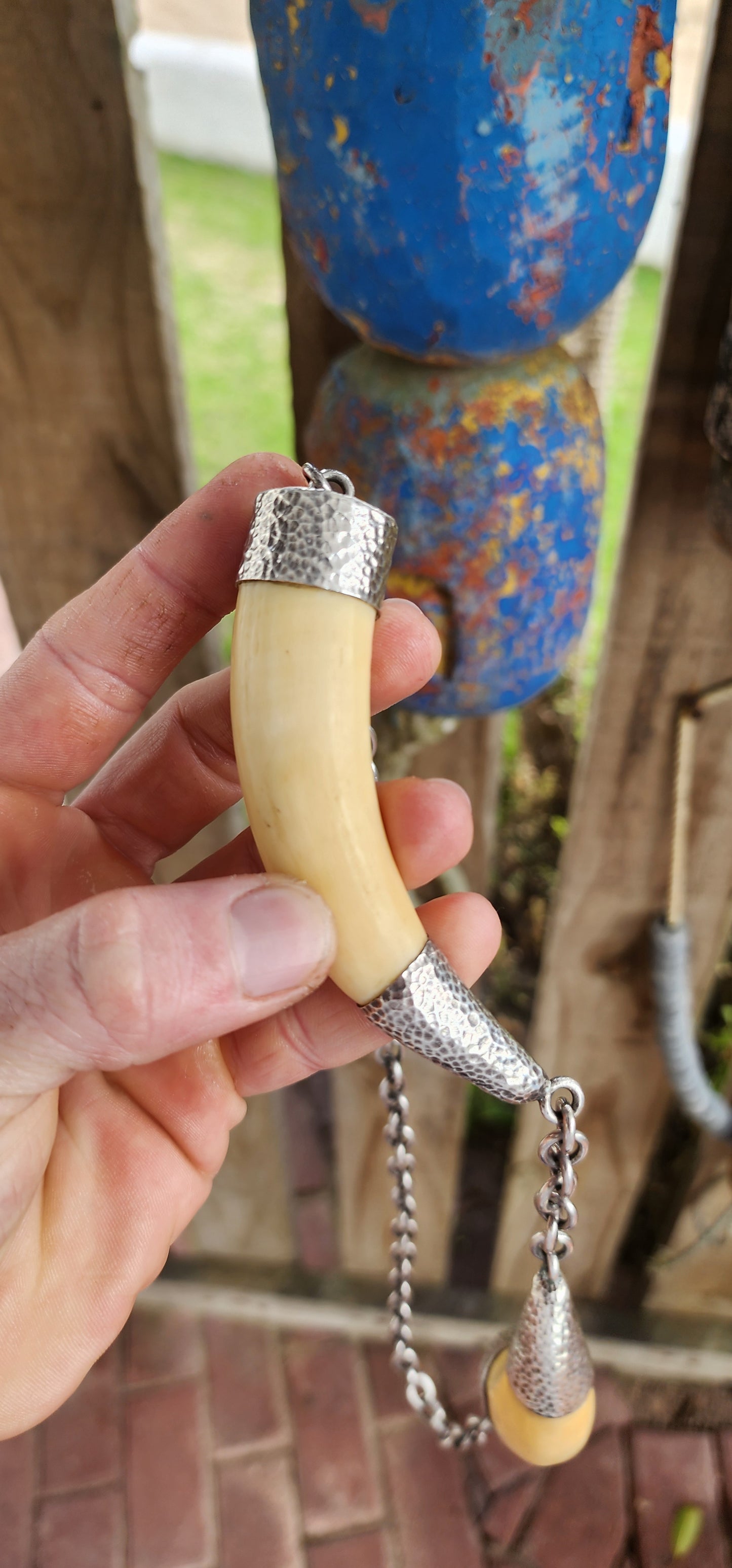 This extraordinary antique STATEMENT necklace radiates bold Viking spirit and primal strength. Its centerpiece features two impressive and large wild boar tusks, naturally aged to a warm creamy hue that speaks of history and heritage.