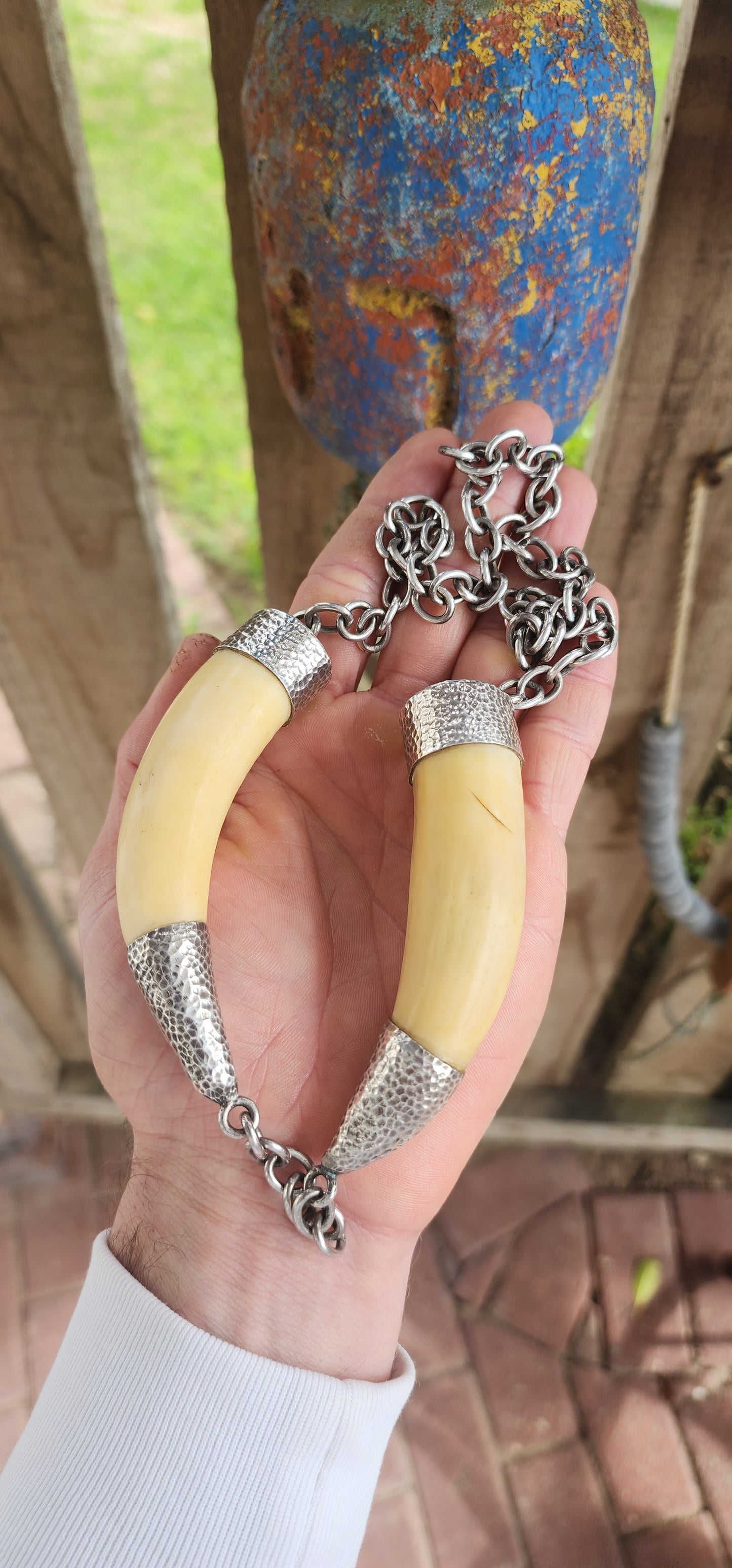 This extraordinary antique STATEMENT necklace radiates bold Viking spirit and primal strength. Its centerpiece features two impressive and large wild boar tusks, naturally aged to a warm creamy hue that speaks of history and heritage.