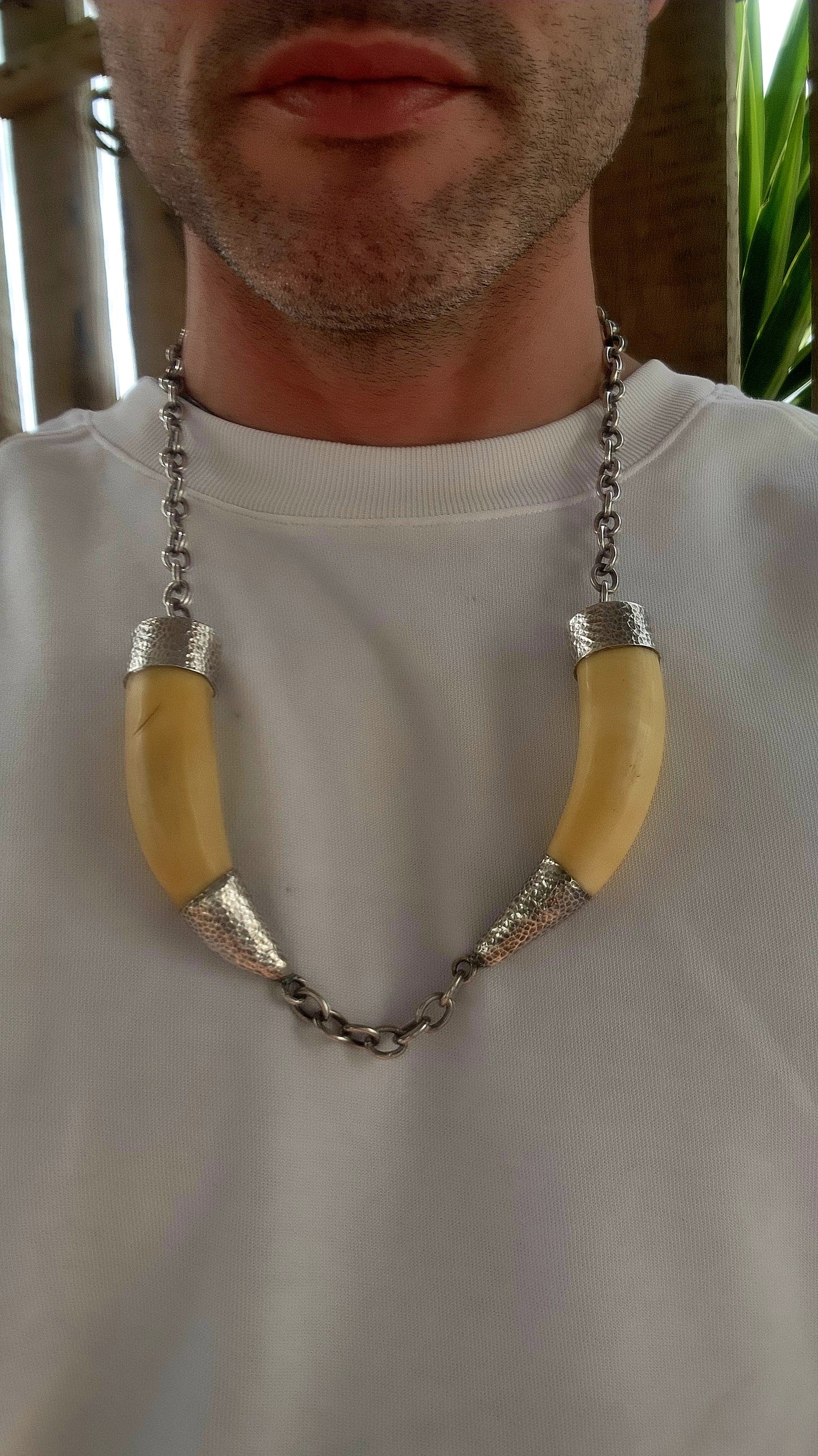 This extraordinary antique STATEMENT necklace radiates bold Viking spirit and primal strength. Its centerpiece features two impressive and large wild boar tusks, naturally aged to a warm creamy hue that speaks of history and heritage.