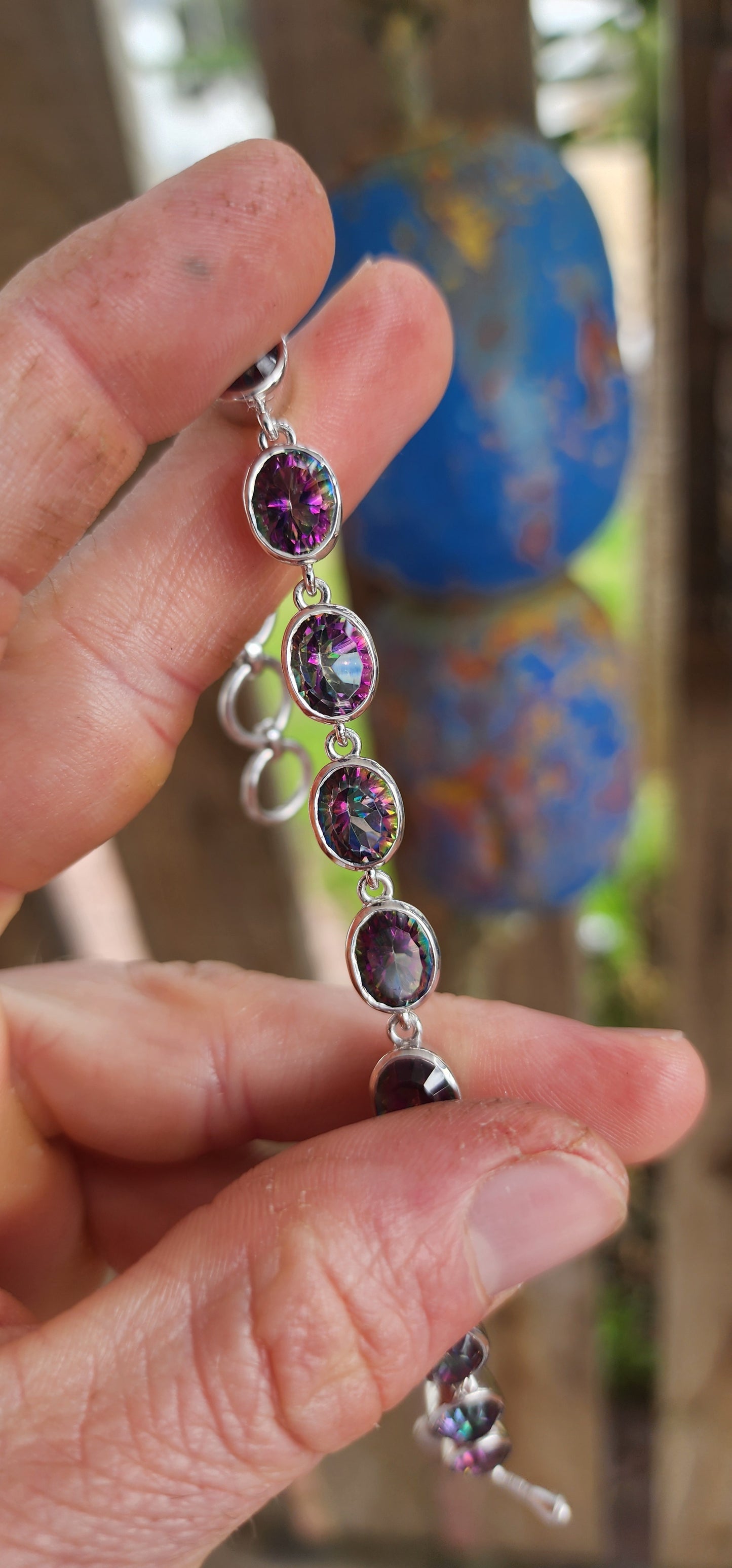 This striking bracelet is crafted in sterling silver in a classic tennis-style design, giving it both elegance and versatility. It features a continuous lineup of 11 generously sized oval-cut Mystic Topaz gemstones.