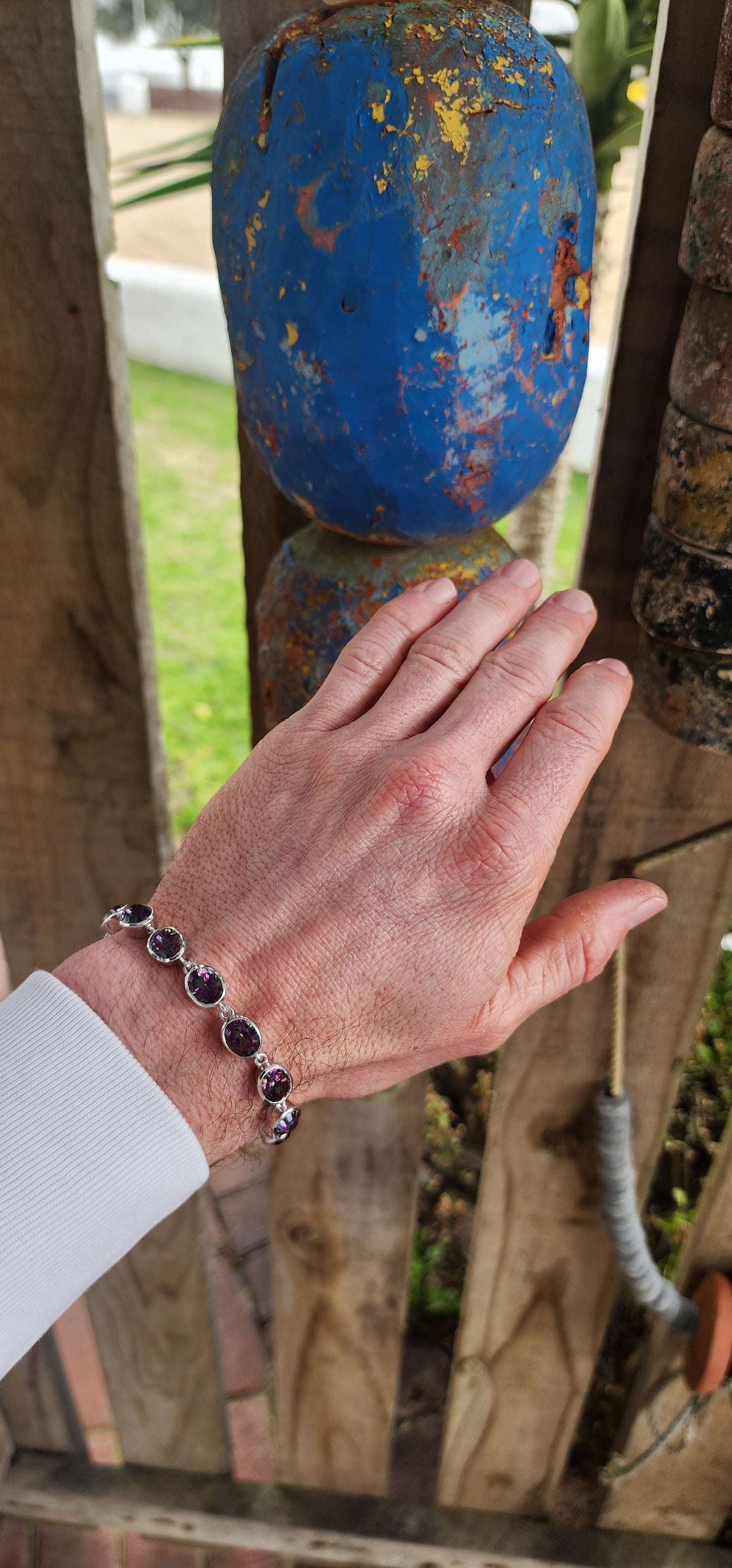 This striking bracelet is crafted in sterling silver in a classic tennis-style design, giving it both elegance and versatility. It features a continuous lineup of 11 generously sized oval-cut Mystic Topaz gemstones.