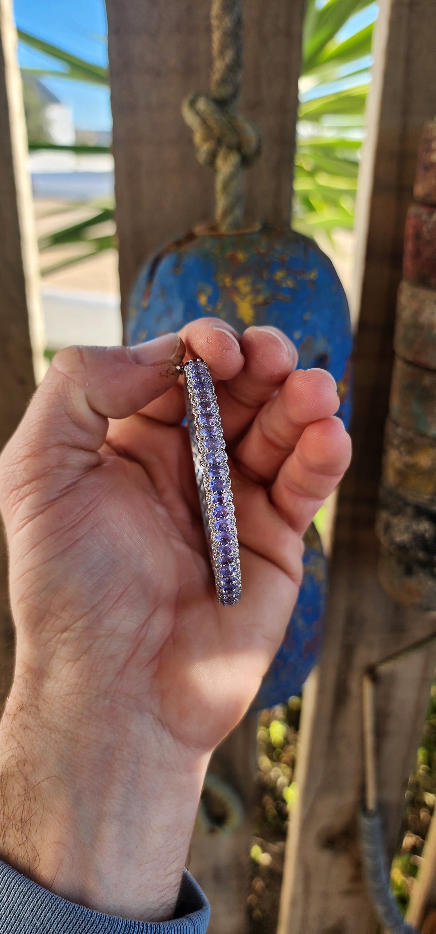 This classical sterling silver clip bangle dazzles with its timeless design and luxurious gemstone line-up. The front half of the bangle features a scalloped gallery adorned with 25 oval-cut Tanzanite gemstones.