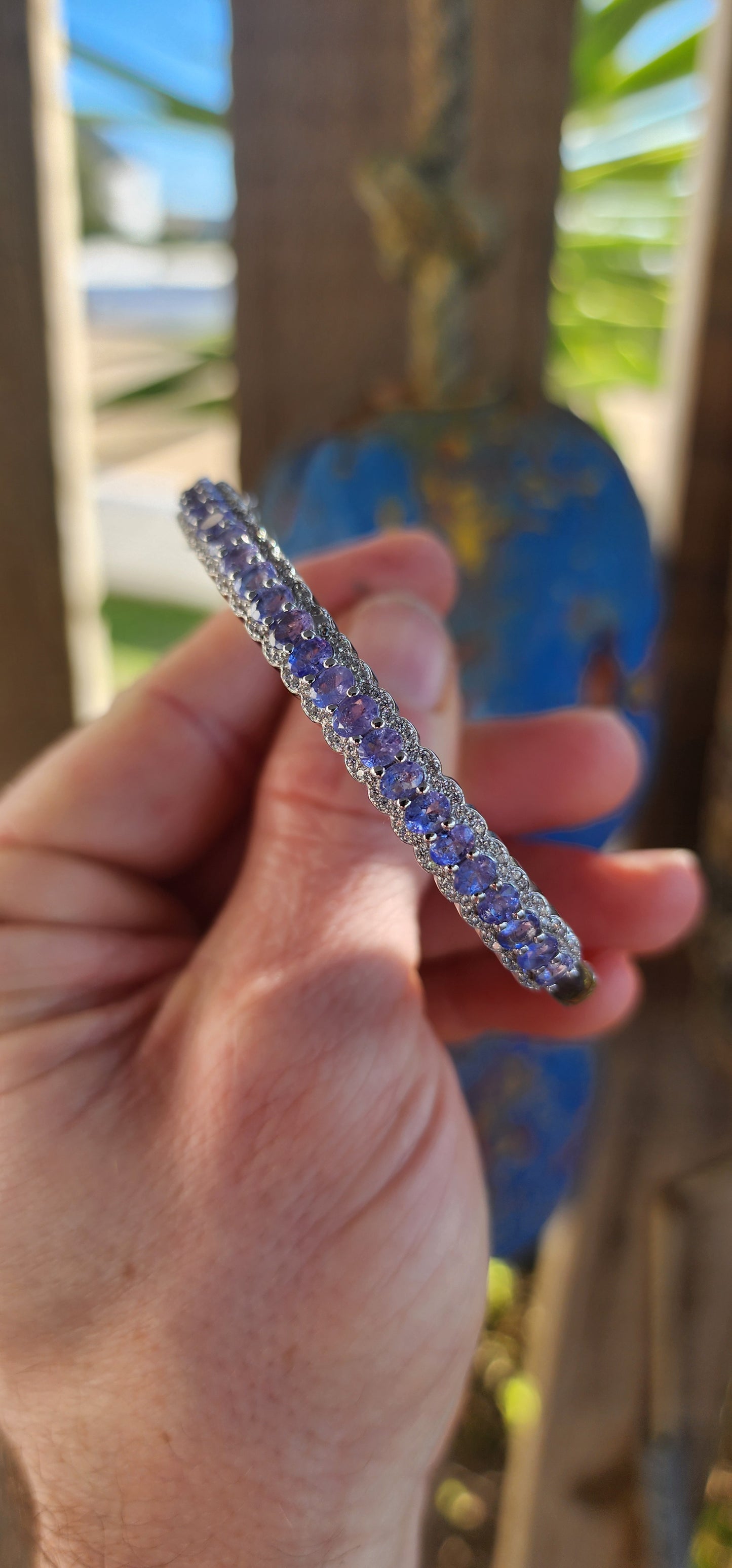 This classical sterling silver clip bangle dazzles with its timeless design and luxurious gemstone line-up. The front half of the bangle features a scalloped gallery adorned with 25 oval-cut Tanzanite gemstones.