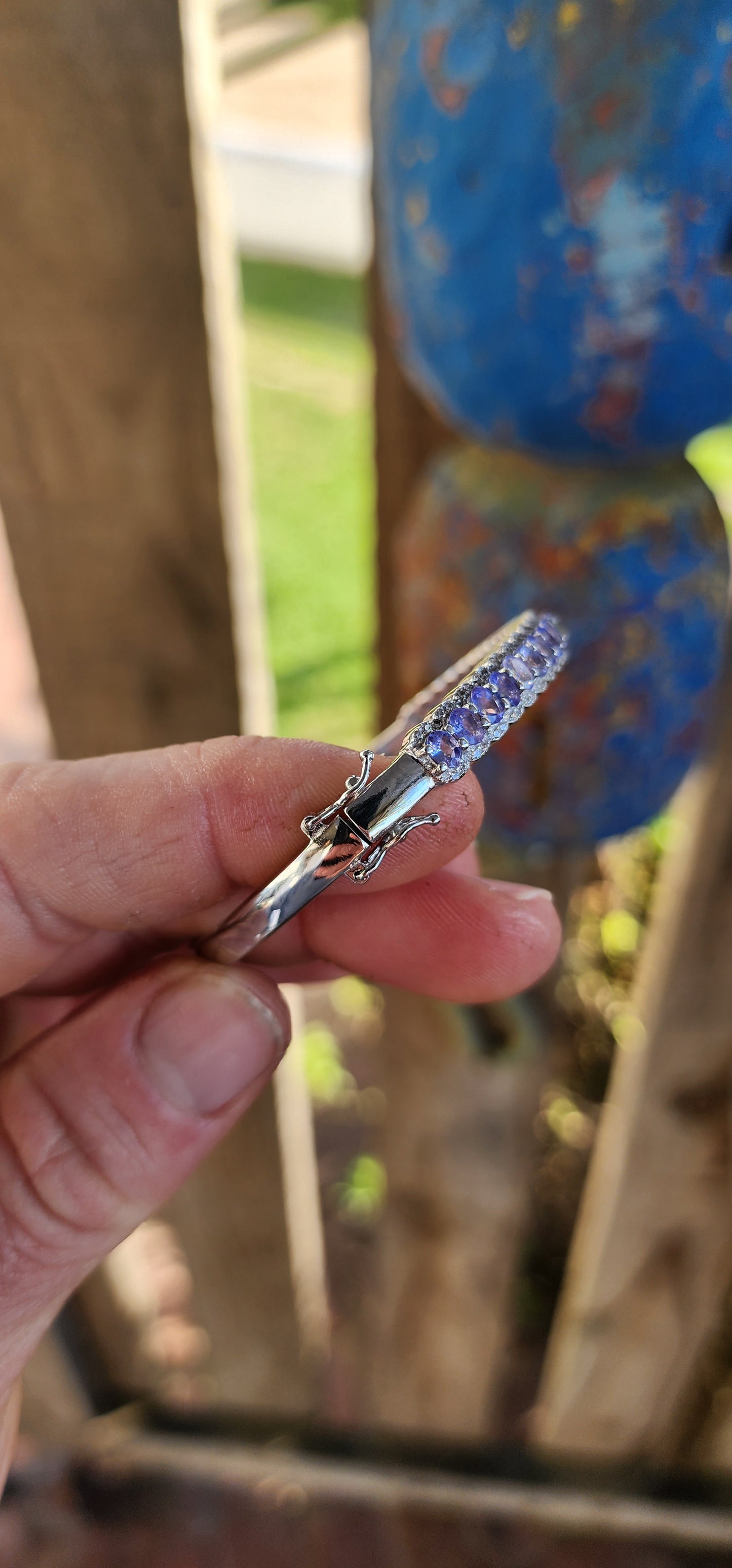 This classical sterling silver clip bangle dazzles with its timeless design and luxurious gemstone line-up. The front half of the bangle features a scalloped gallery adorned with 25 oval-cut Tanzanite gemstones.