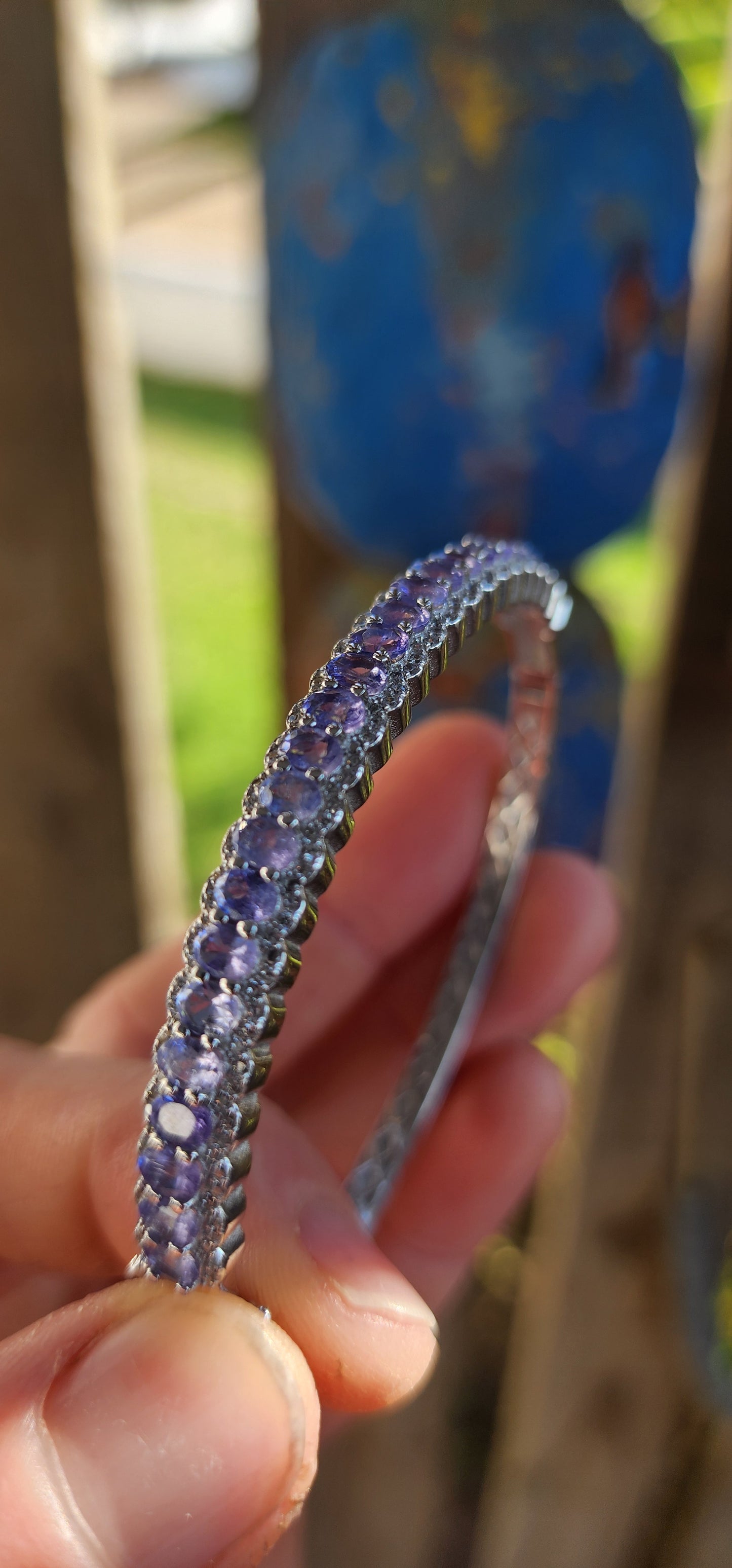 This classical sterling silver clip bangle dazzles with its timeless design and luxurious gemstone line-up. The front half of the bangle features a scalloped gallery adorned with 25 oval-cut Tanzanite gemstones.