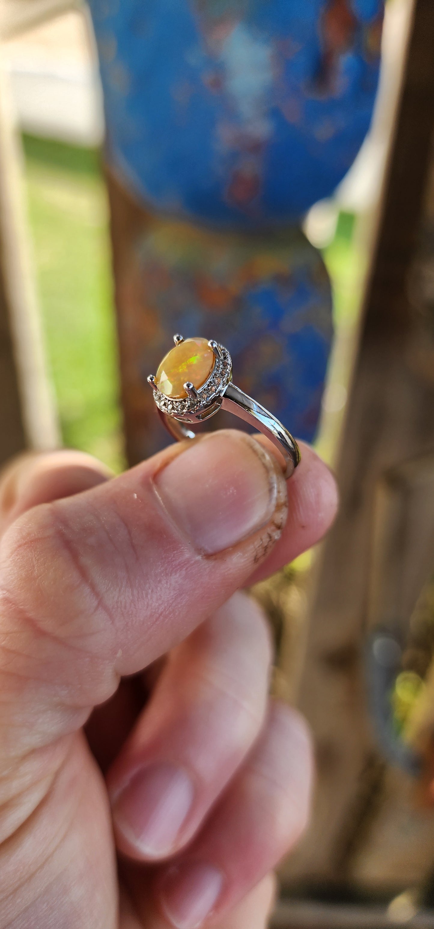 A timeless classic with a magical twist! This sterling silver beauty showcases a glowing orange oval-cut Ethiopian opal, prong set at the center where it shimmers with fiery flashes of orange, green, and golden yellow – like a sunset captured in stone.