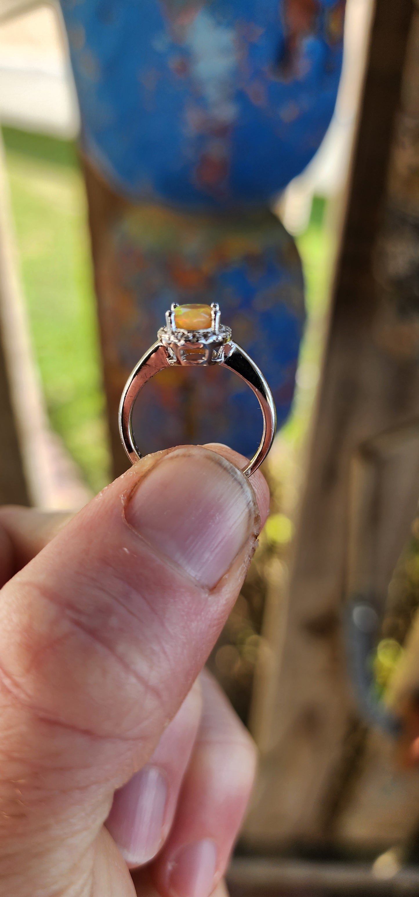 A timeless classic with a magical twist! This sterling silver beauty showcases a glowing orange oval-cut Ethiopian opal, prong set at the center where it shimmers with fiery flashes of orange, green, and golden yellow – like a sunset captured in stone.