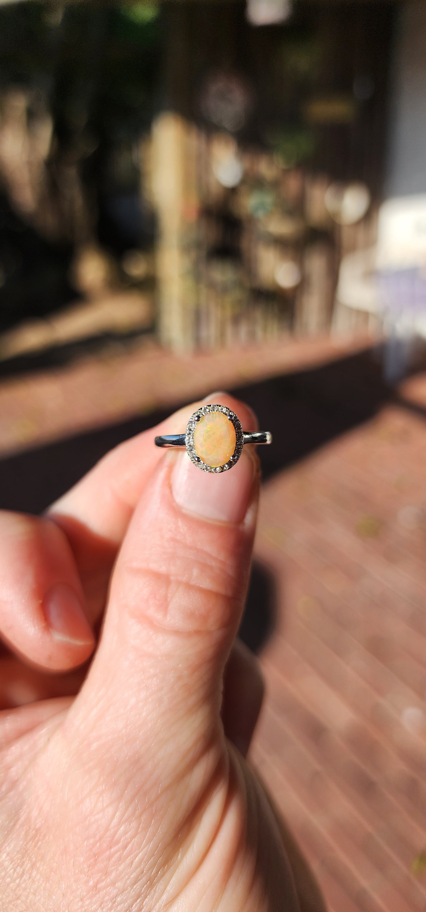 A timeless classic with a magical twist! This sterling silver beauty showcases a glowing orange oval-cut Ethiopian opal, prong set at the center where it shimmers with fiery flashes of orange, green, and golden yellow – like a sunset captured in stone.