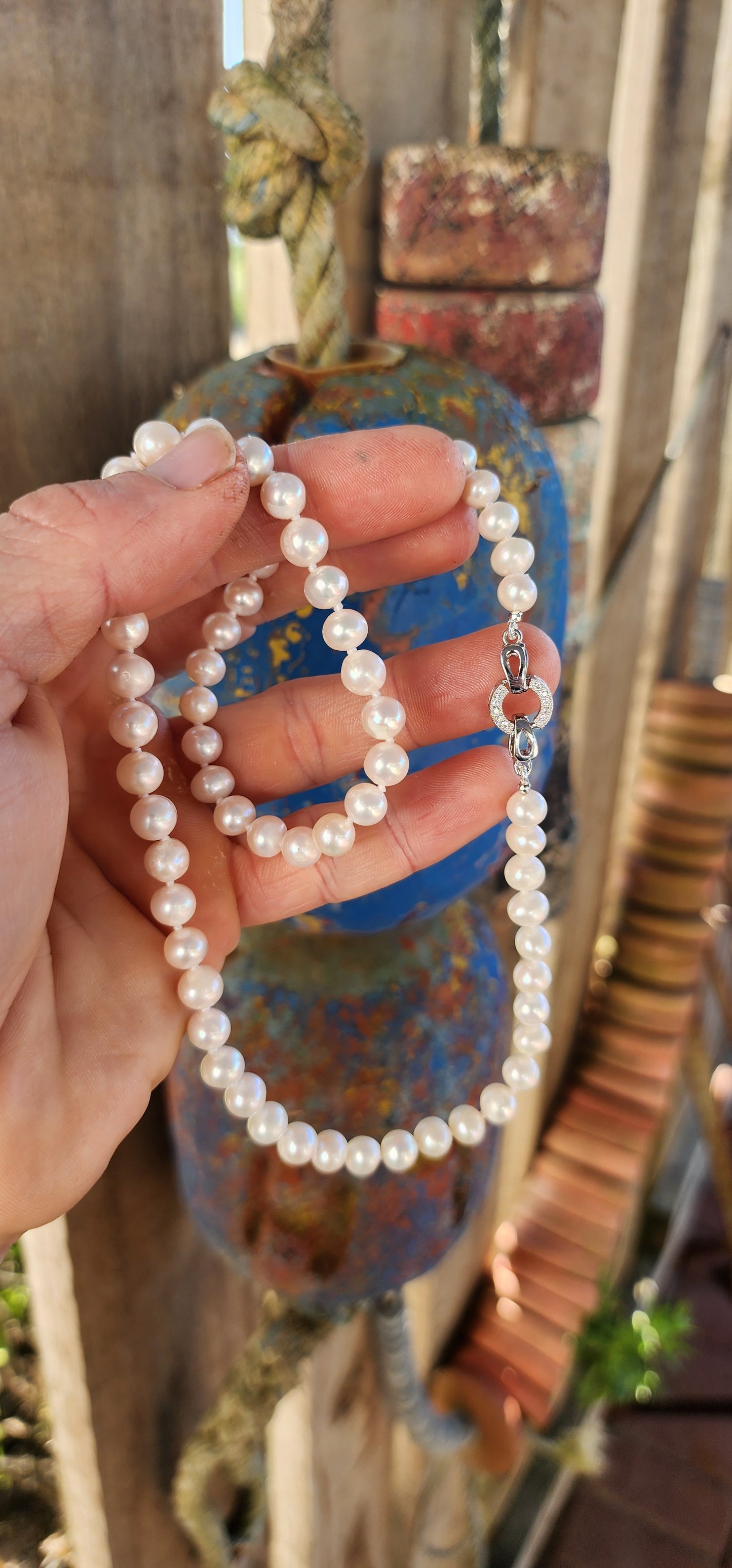 This elegant necklace is a classic strand of freshwater cultured pearls, a timeless jewel that has graced wardrobes for centuries.