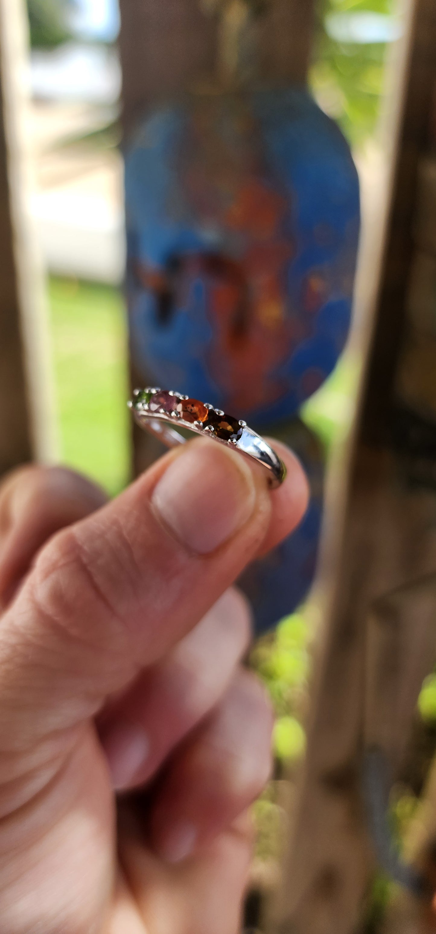 Let your fingers tell a story of color and wonder with this enchanting sterling silver half-eternity ring.